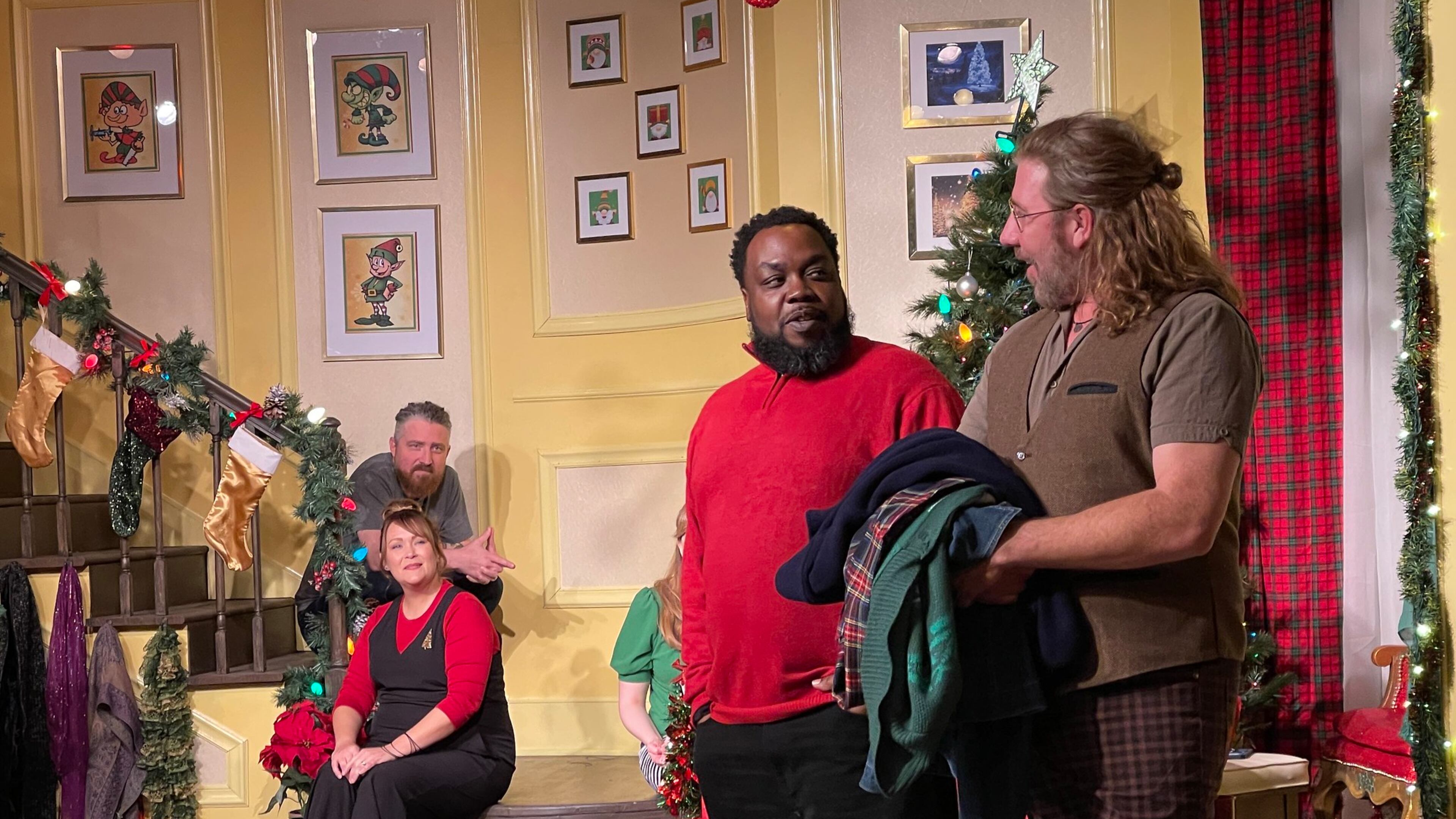 Narrator Topher Payne greets special guest Enoch King during a performance of "Y'allmark Christmas," as improvisers Amber Nash and Kevin Gillese watch from the steps.