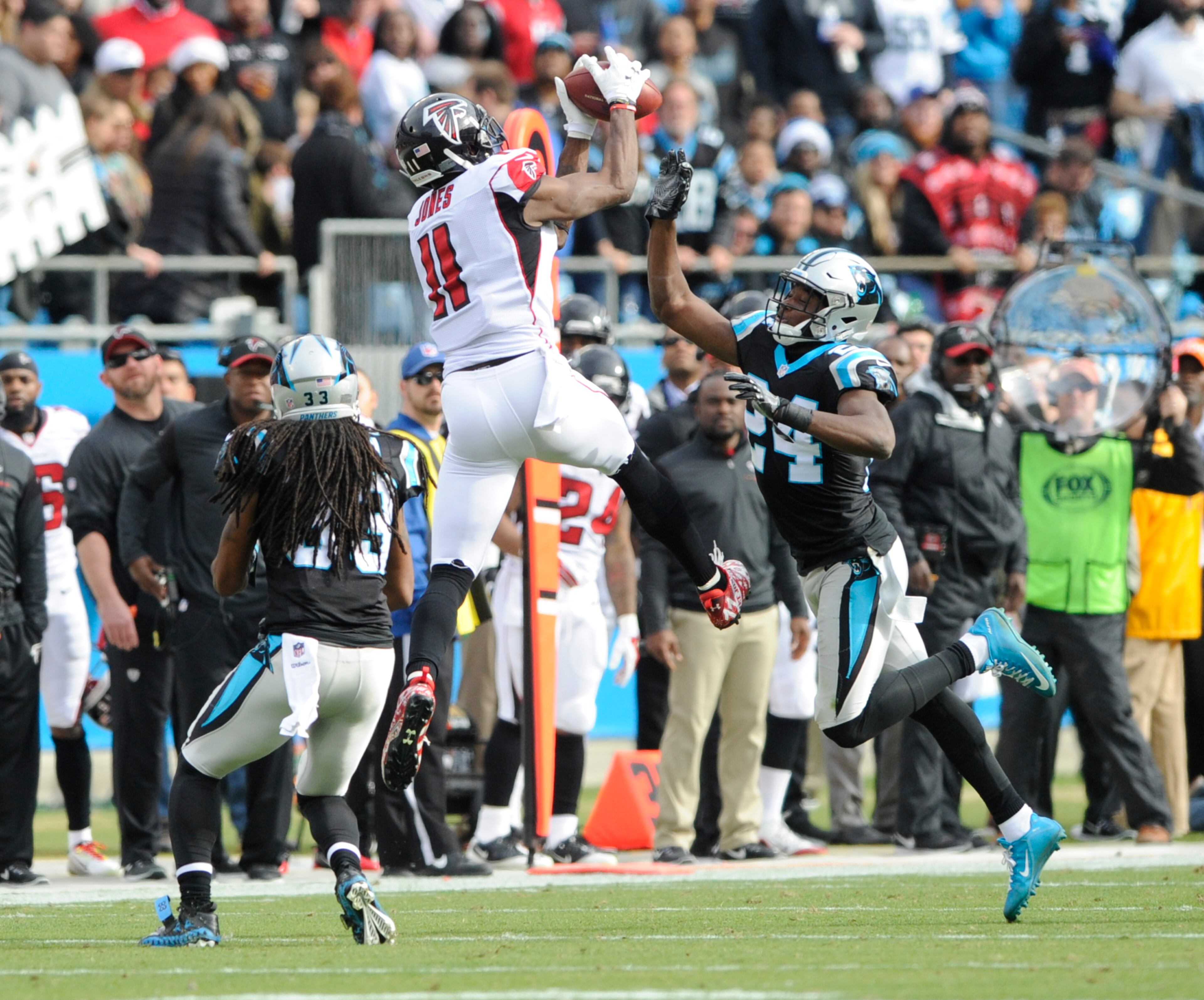 Julio Jones (11) catches a pass as Carolina Panthers' Tre Boston (33) and James Bradberry (24) defend.