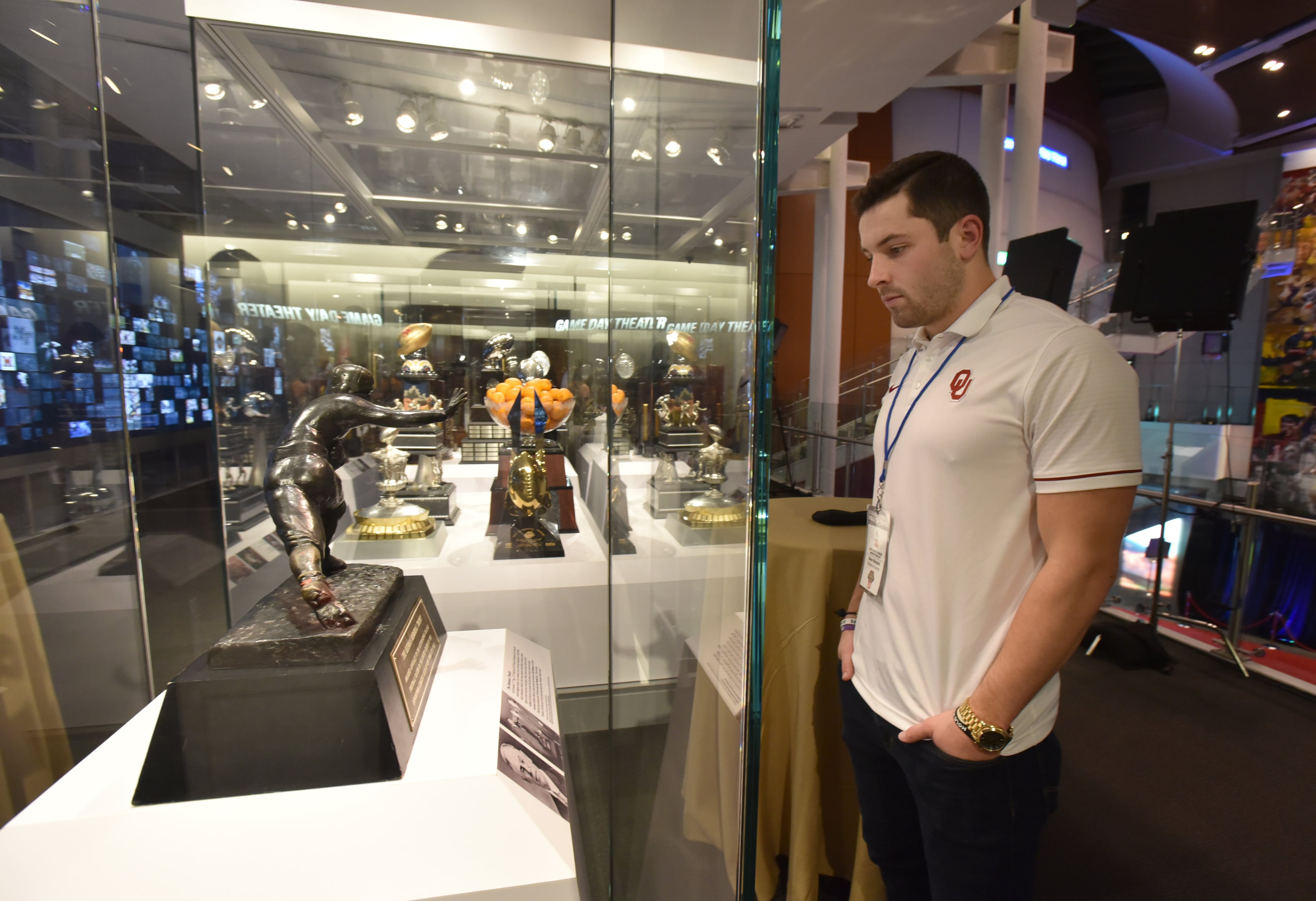 December 6, 2017 Atlanta - Oklahoma quarterback Baker Mayfield looks at the Heisman Memorial Trophy after he spoke to members of the press a day before the "College Football Awards" show at College Football Hall of Fame on Wednesday, December 6, 2017. HYOSUB SHIN / HSHIN@AJC.COM