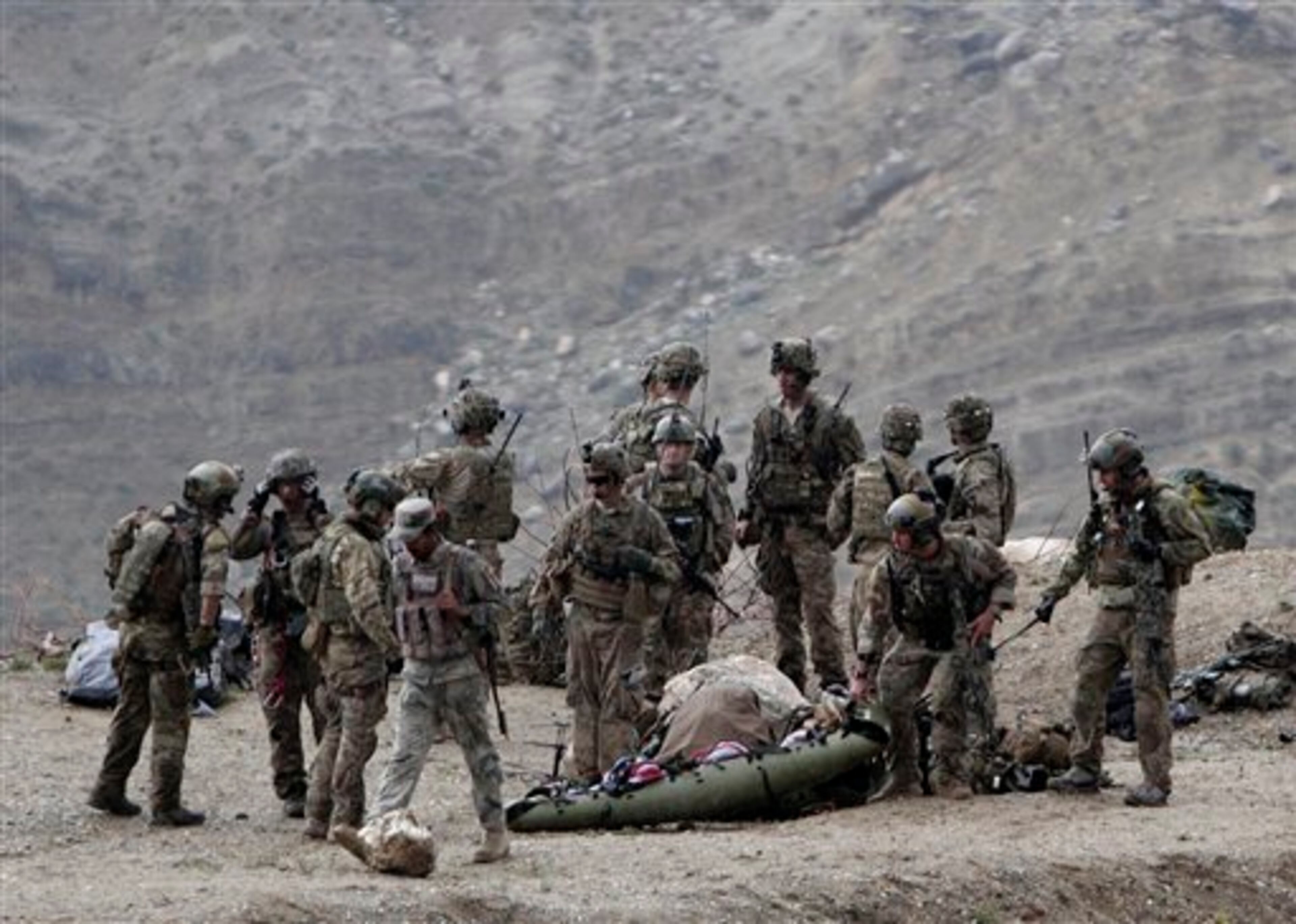 U.S. soldiers evacuate a dead body as they arrive to the scene after a NATO helicopter crashed in a field killing two American service members, near Gerakhel, eastern Afghanistan, Tuesday, April 9, 2013. The U.S.-led International Security Assistance Force said the cause of the crash is under investigation but initial reporting indicates there was no enemy activity in the area at the time. It did not immediately identify the nationalities of those killed. But a senior U.S. official confirmed they were Americans. (AP Photo/Rahmat Gul)
