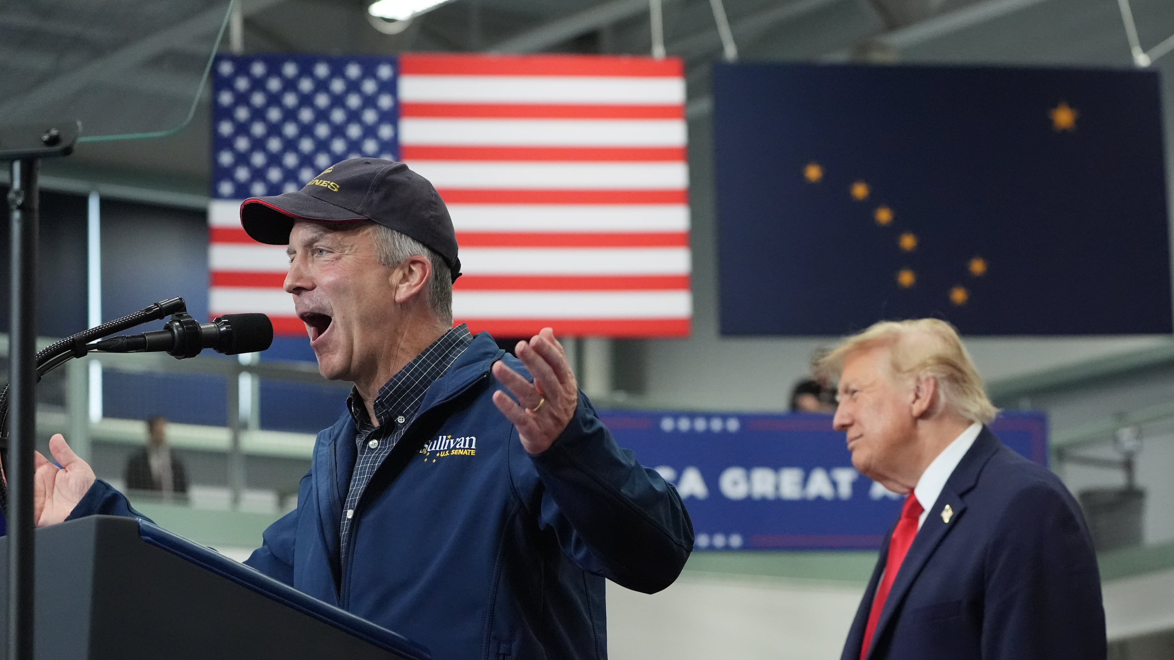 President Donald Trump listens as Sen. Dan Sullivan, R-Alaska, speaks at a campaign rally at the Curtis D. Menard Memorial Sports Center, Tuesday, Oct. 13, 2026, in Wasilla, Alaska. (AP Photo/Alex Brandon)