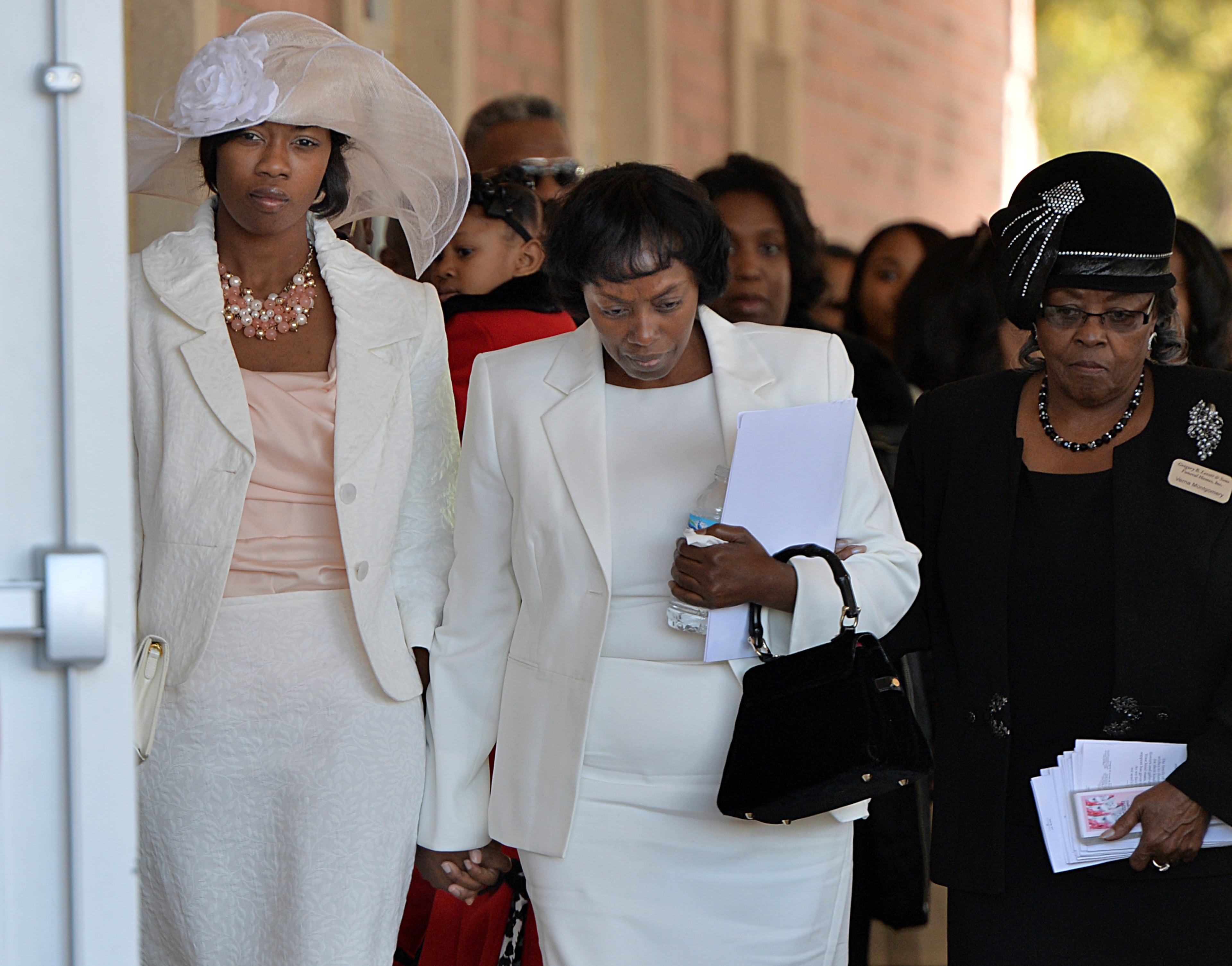 Emani Moss' aunt Sharoniece Rich (left) and Emani Moss' grandmother Robin Moss (center) are escorted by funeral home staff Vema Montgomery as they enter the funeral service for Emani Moss, who was found dead, her body burned, in a trash can, at Gregory B. Levett & Sons Funeral Home in Lawrenceville on Wednesday, November 13, 2013. Emani Moss will be laid to rest Wednesday in Gwinnett after the grandmother won court approval to bury the child. Emani's grandmother had to get a court order to keep the birth mother, who surrendered custody, from claiming the body. HYOSUB SHIN / HSHIN@AJC.COM