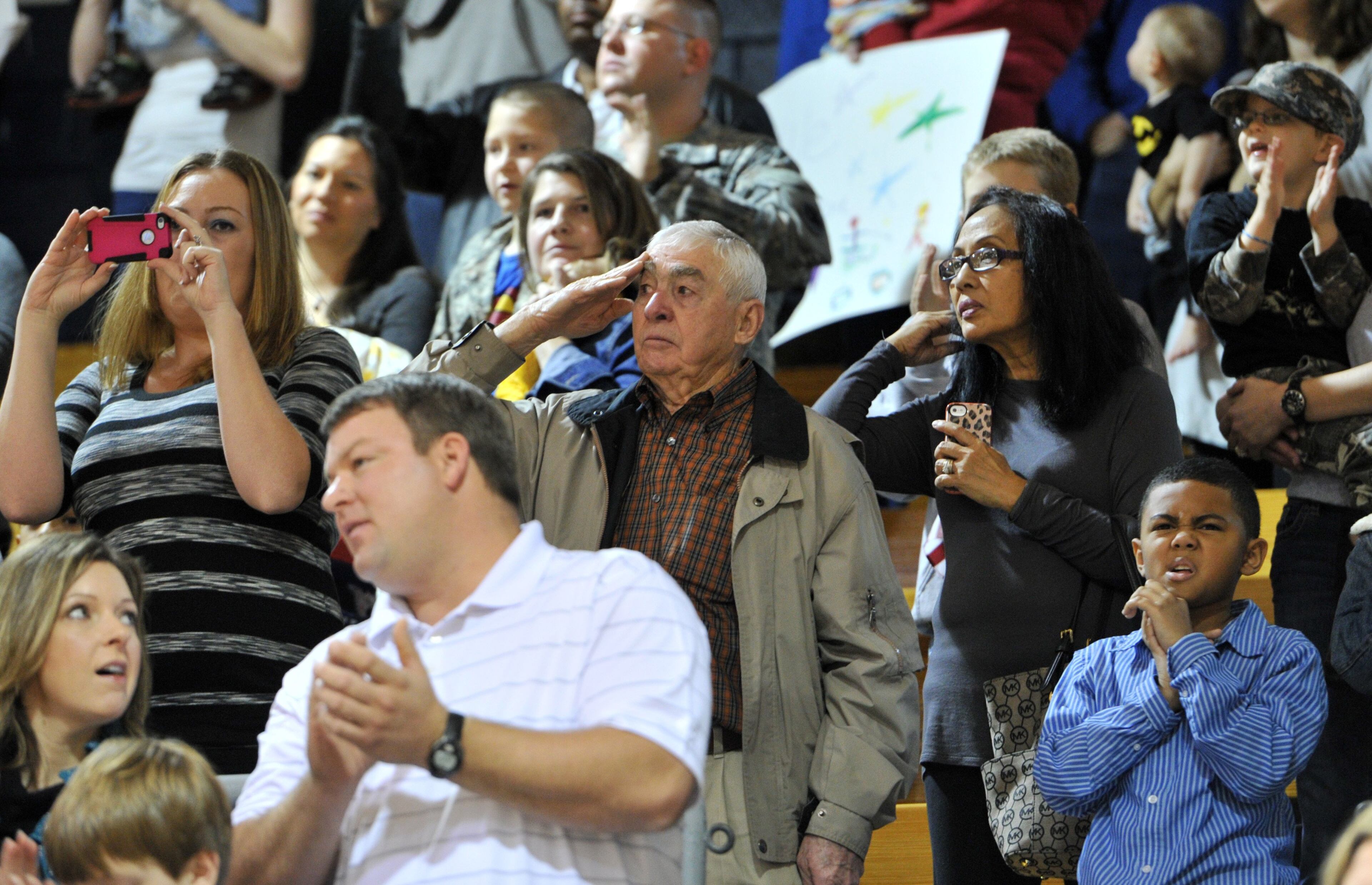 A man salutes as the troops enter during welcoming home ceremony at Elbert County gym in Elberton on Saturday, Jan. 11, 2014. Georgia Army National Guard's own 648th Maneuver Enhancement Brigade is welcoming home on Saturday over 200 Guardsmen with the 1-214th Field Artillery Battalion from nearly a year in Afghanistan where they conducted base defense operations in Western Afghanistan.