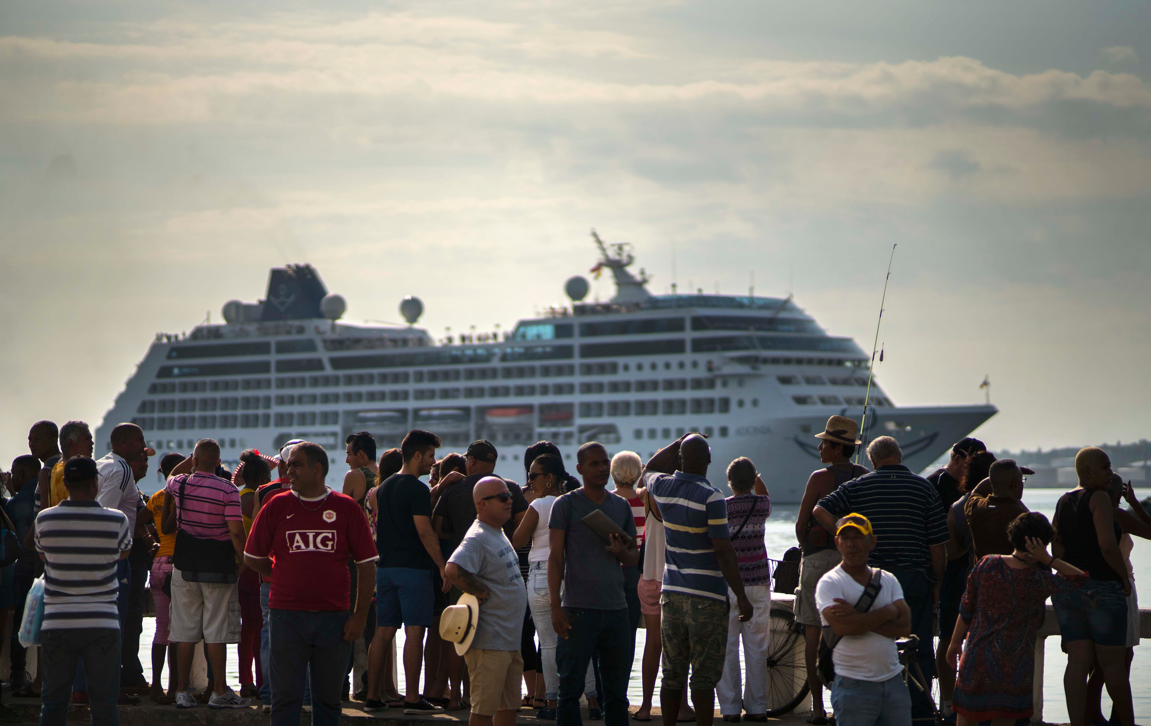 People watch Carnival's Adonia cruise ship arrive from Miami, in Havana, Cuba, Monday, May 2, 2016. The Adonia's arrival is the first step toward a future in which thousands of ships a year could cross the Florida Straits, long closed to most U.S.-Cuba traffic due to tensions that once brought the world to the brink of nuclear war. (AP Photo/Ramon Espinosa)