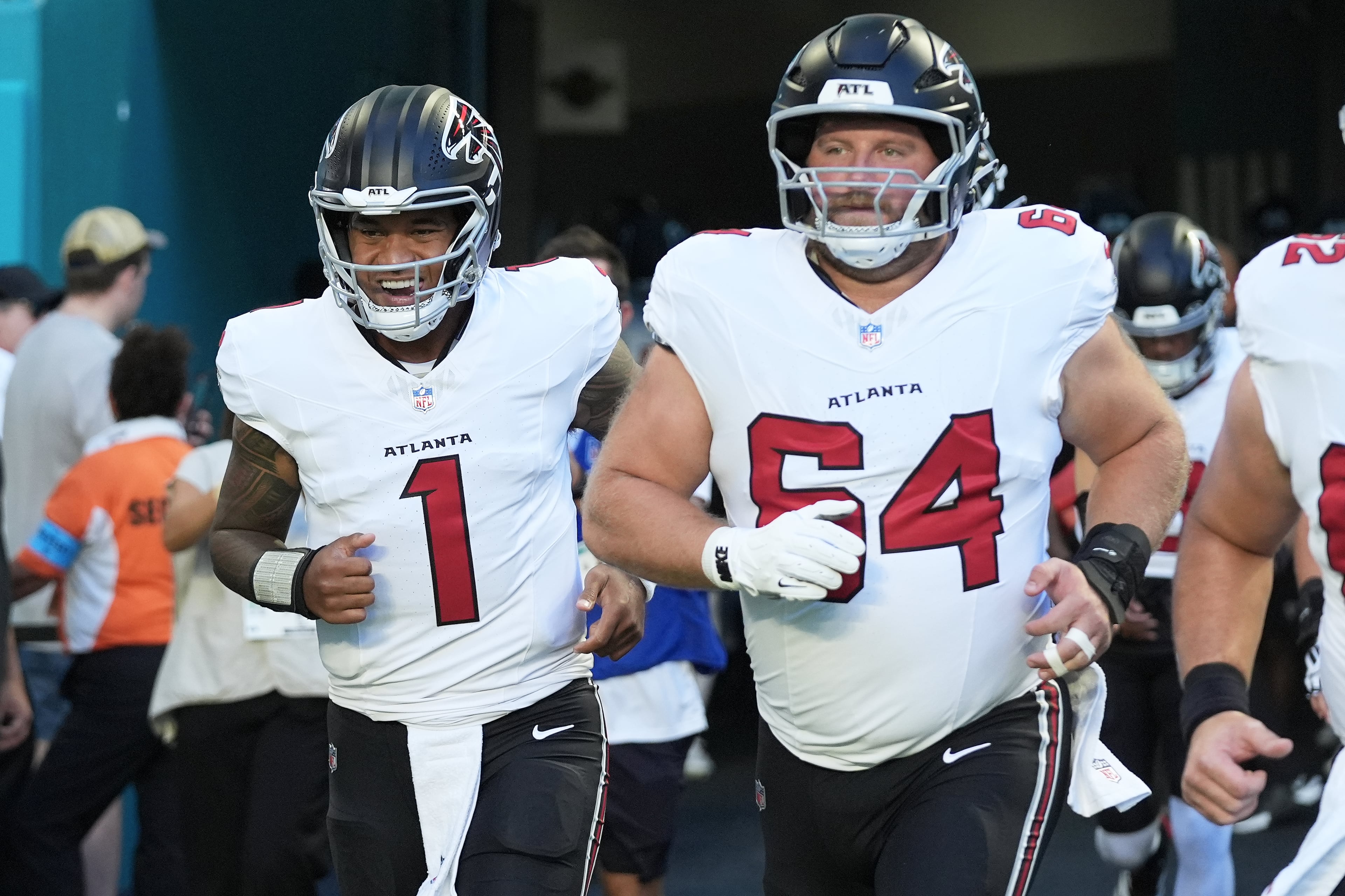 Atlanta Falcons quarterback Tua Tagovailoa (1) and offensive lineman Ryan Neuzil (64) jog onto the field before an NFL preseason football game, Friday, Aug. 28, 2026, in Miami Gardens, Fla. (AP Photo/Lynne Sladky)