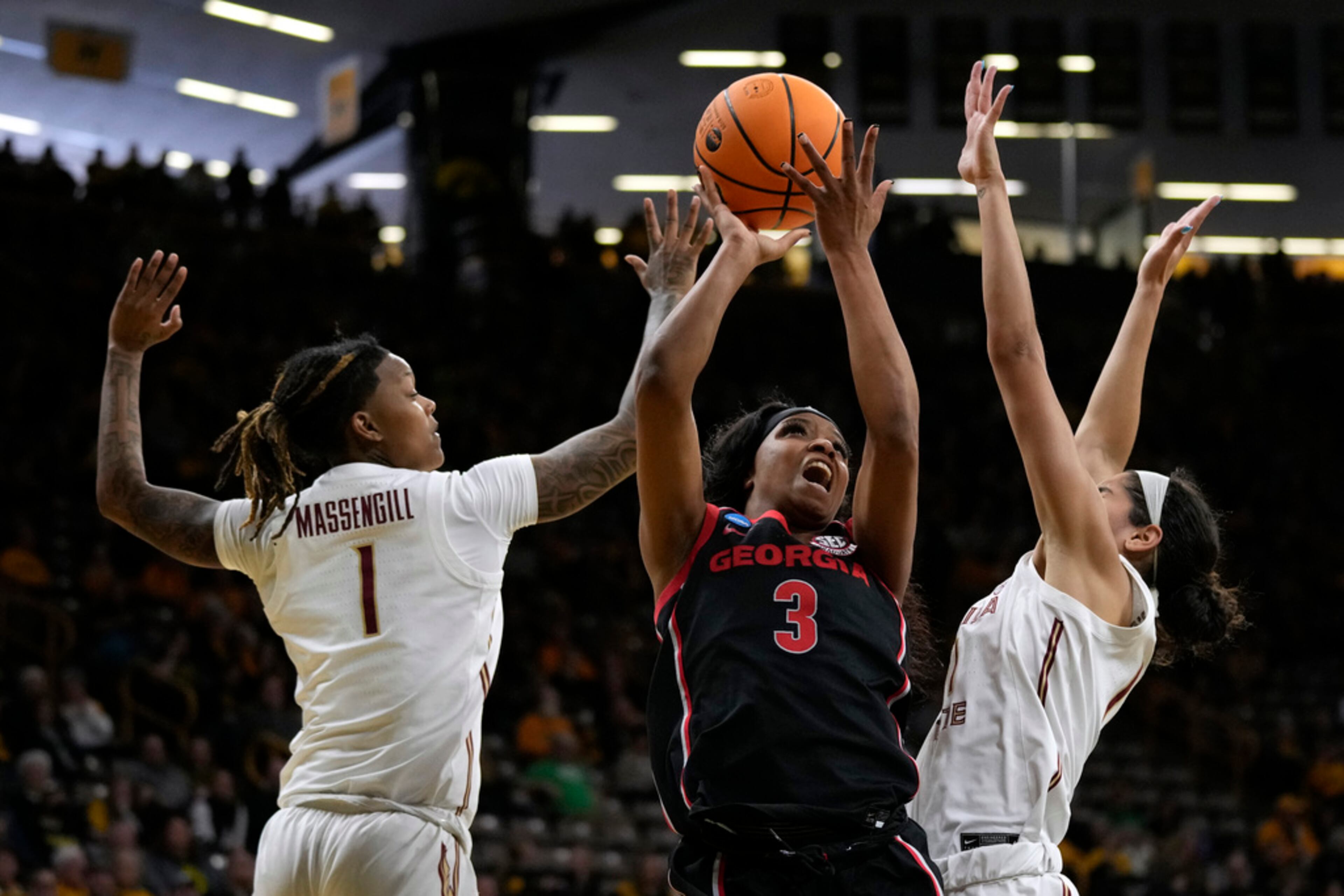 Georgia guard Diamond Battles (3) drives to the basket between Florida State guard Jazmine Massengill, left, and guard Taylor O'Brien, right, in the second half of a first-round college basketball game in the NCAA Tournament, Friday, March 17, 2023, in Iowa City, Iowa. (AP Photo/Charlie Neibergall)
