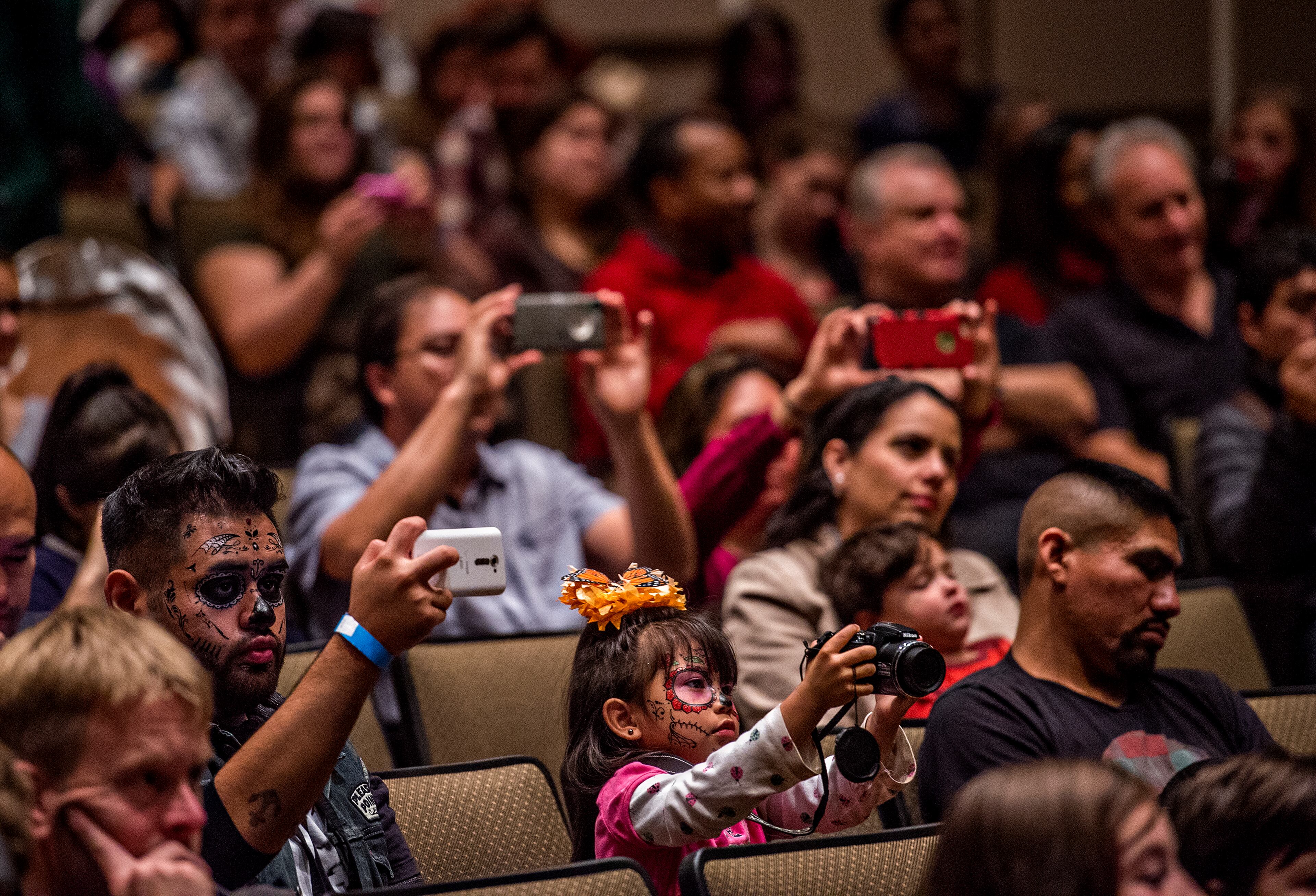 November 1, 2015 Atlanta - Leidie Denisse Canizalez-Perez (center) takes photos of the Atlanta Symphony Orchestra as they perform during the Dia De Muertos, or Day of the Dead, Festival at the Atlanta History Center on Sunday, November 1, 2015. The festival featured storytelling, crafts, and authentic Mexican food and entertainment while teaching about the day that traditionally honors dead friends and loved ones. JONATHAN PHILLIPS / SPECIAL