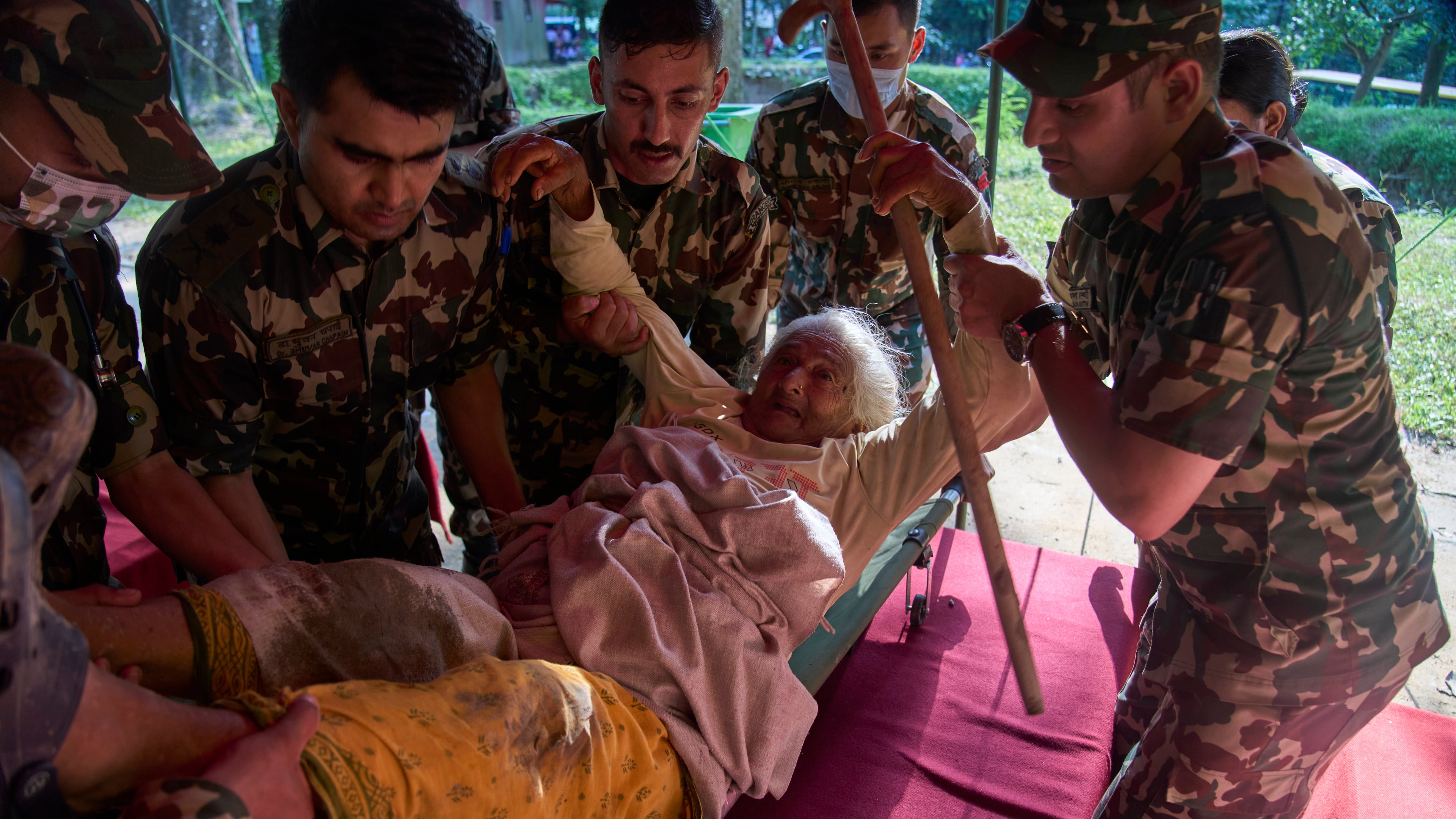 An elderly survivor is taken to a makeshift hospital for treatment at the army's Maithali barracks after being rescued from flash flooding in Nuwakot district, Nepal, Thursday, Aug. 27, 2026. (AP Photo/Niranjan Shrestha)