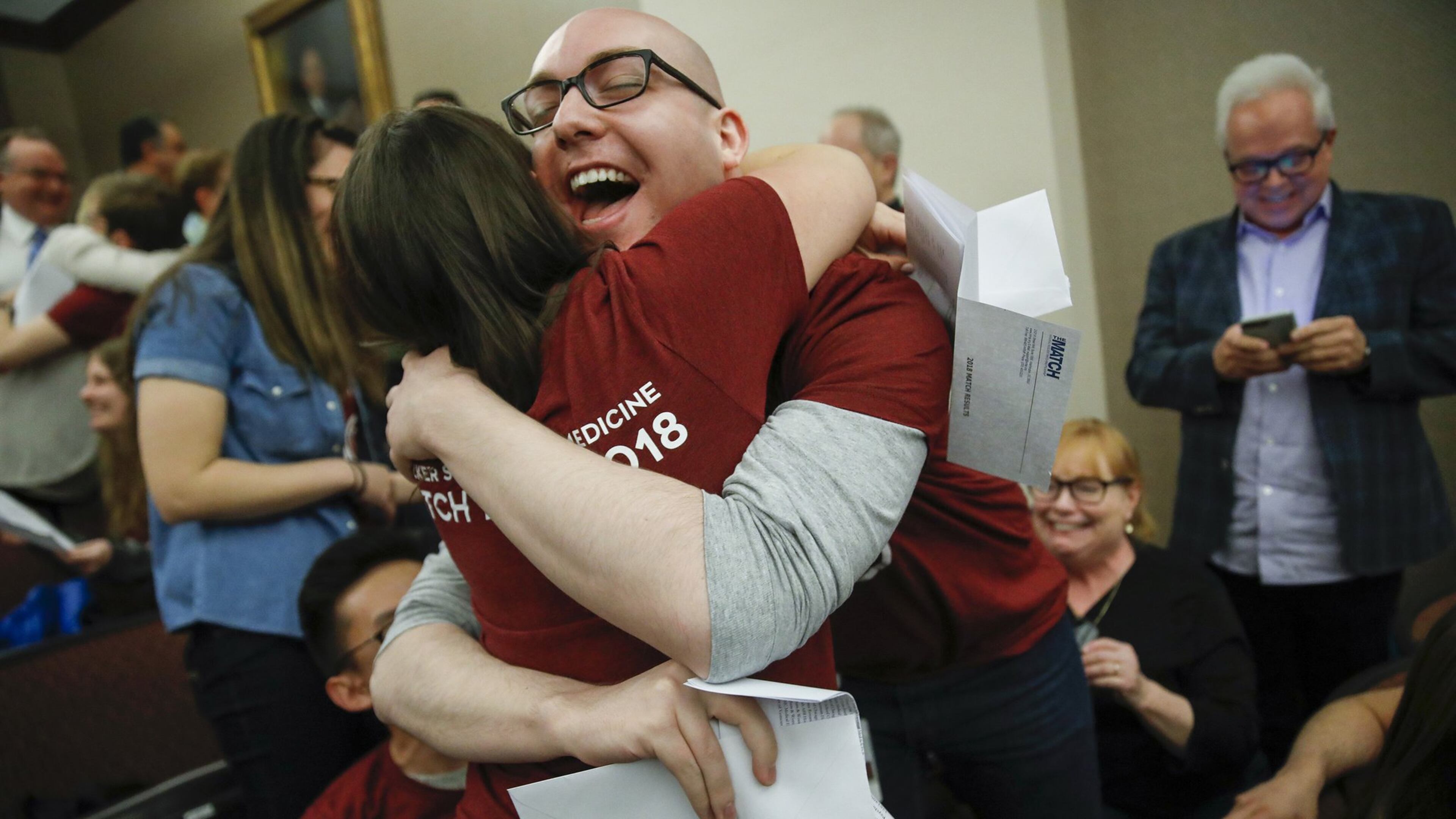 Ren Belcher hugs Mila Grossman after they open their letters during a Match Day event on Friday, March 16, 2018 at the University of Chicago Pritzker School of Medicine on the University of Chicago campus in Chicago, Ill. Belcher and Grossman will have their psychiatry residencies at the same hospital, Massachusetts General Hospital. (Jose M. Osorio/Chicago Tribune/TNS)