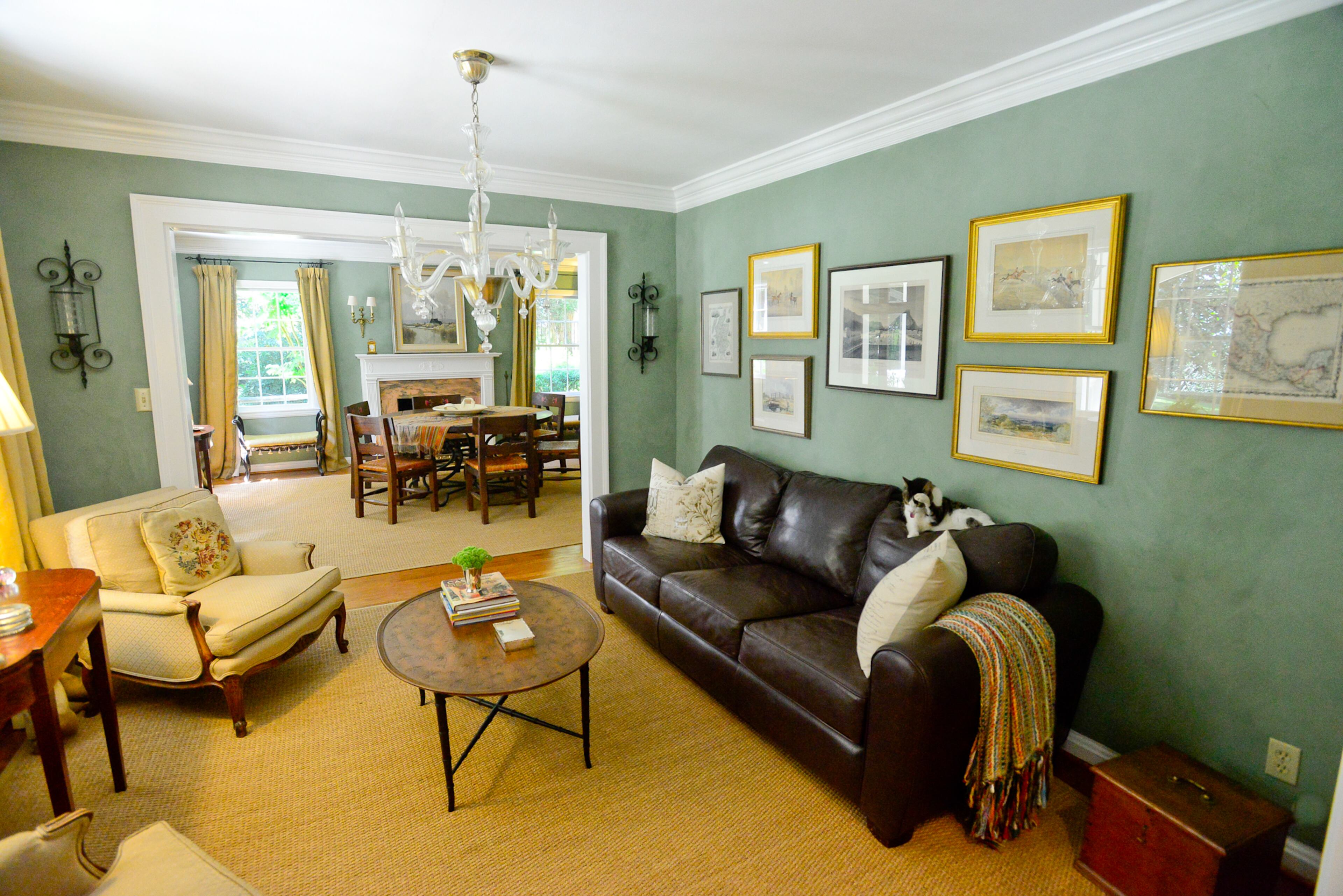 With a view of the dining room through a wide opening, the sitting room has chairs and a light fixture purchased in Dallas.