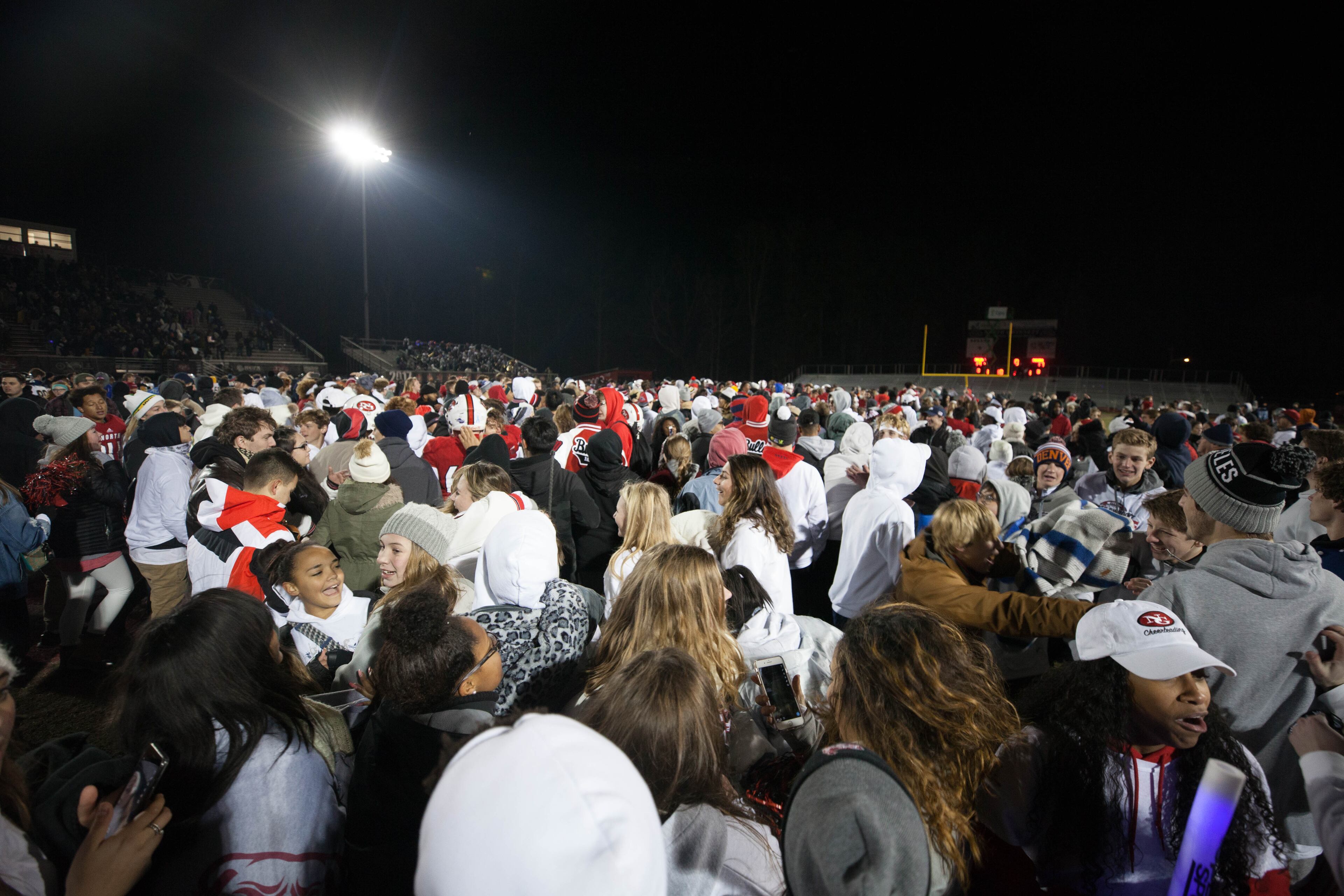 Fans and players storm the field after North Gwinnett High School kicker Cameron Clark (93) kicked the game winning field goal against Colquitt High School during a Class AAAAAAA football championship game, Friday, Dec. 15, 2017, in Suwanee, Ga. North Gwinnett defeated Colquitt County 19-17.