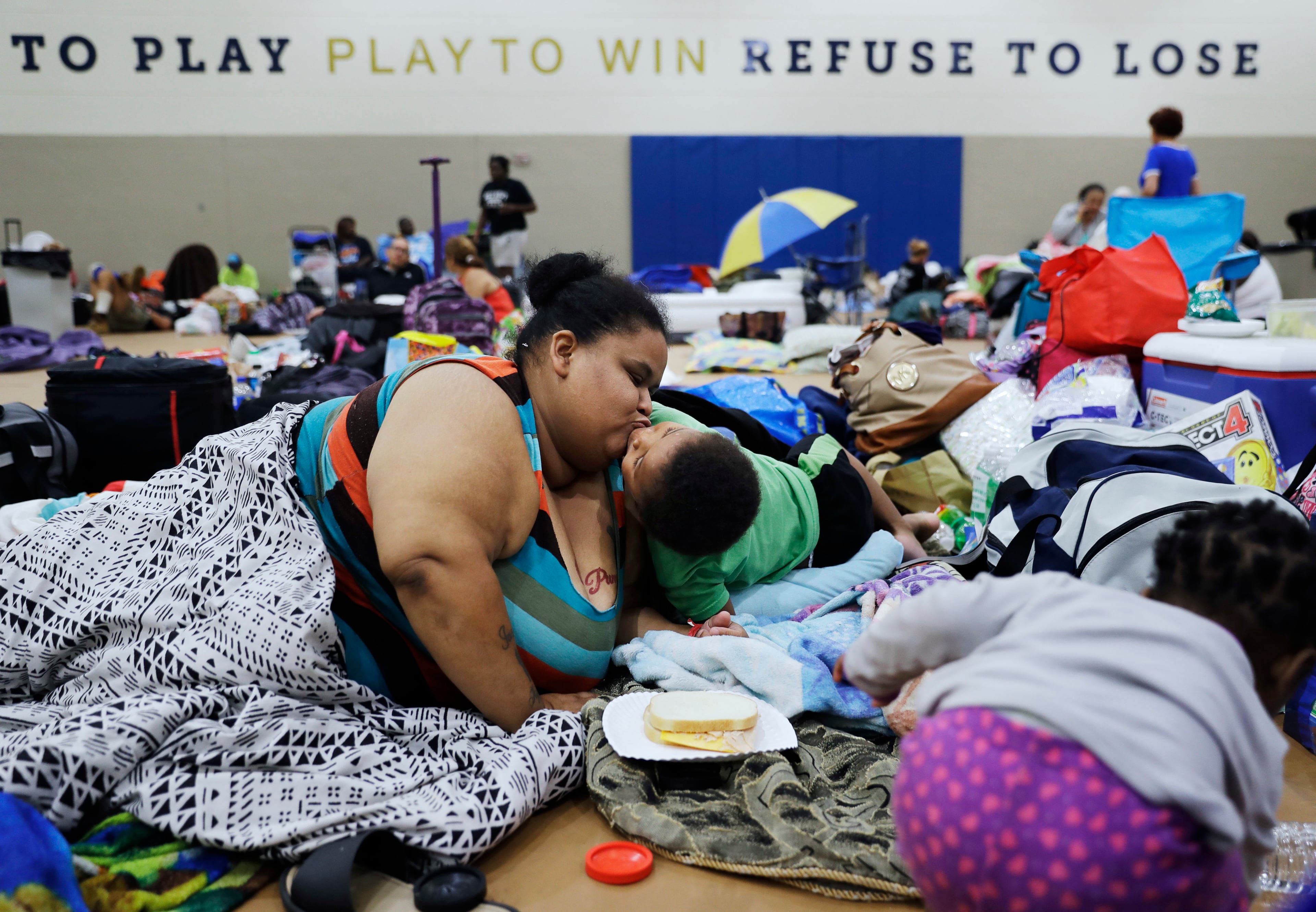 Annette Davis kisses her son Darius, 3, while staying at a shelter in Miami after evacuating from their home in Florida City, Fla., ahead of Hurricane Irma Saturday, Sept. 9, 2017. (AP Photo/David Goldman)
