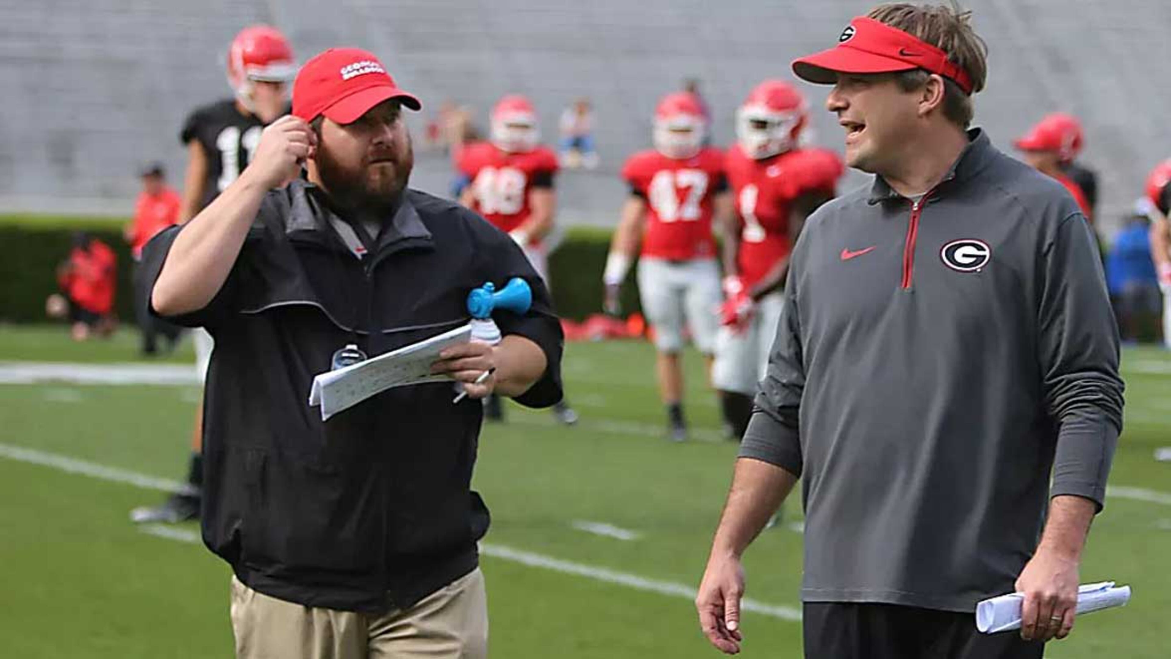 Kevin Purvis (left) talks to Georgia coach Kirby Smith during one of the Bulldogs' summer camps. (Randy Schafer/For DawgNation)