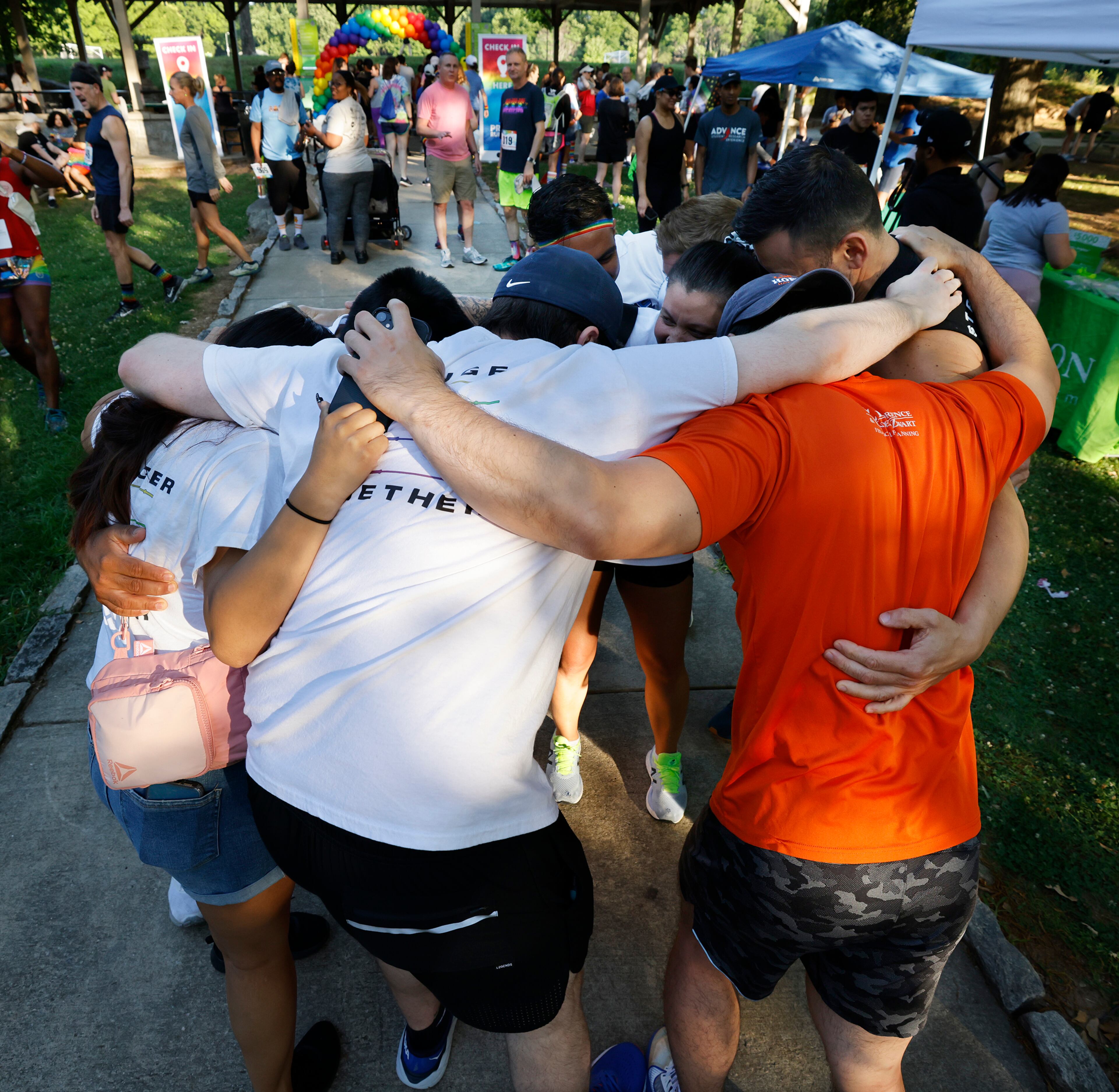 A team from the Crossfit 11:24 gym in Marietta gather for a group hug before the start of the Atlanta Pride Run at Piedmont Park on Sunday, June 5, 2022, in Atlanta. “Curtis Compton / Curtis.Compton@ajc.com”