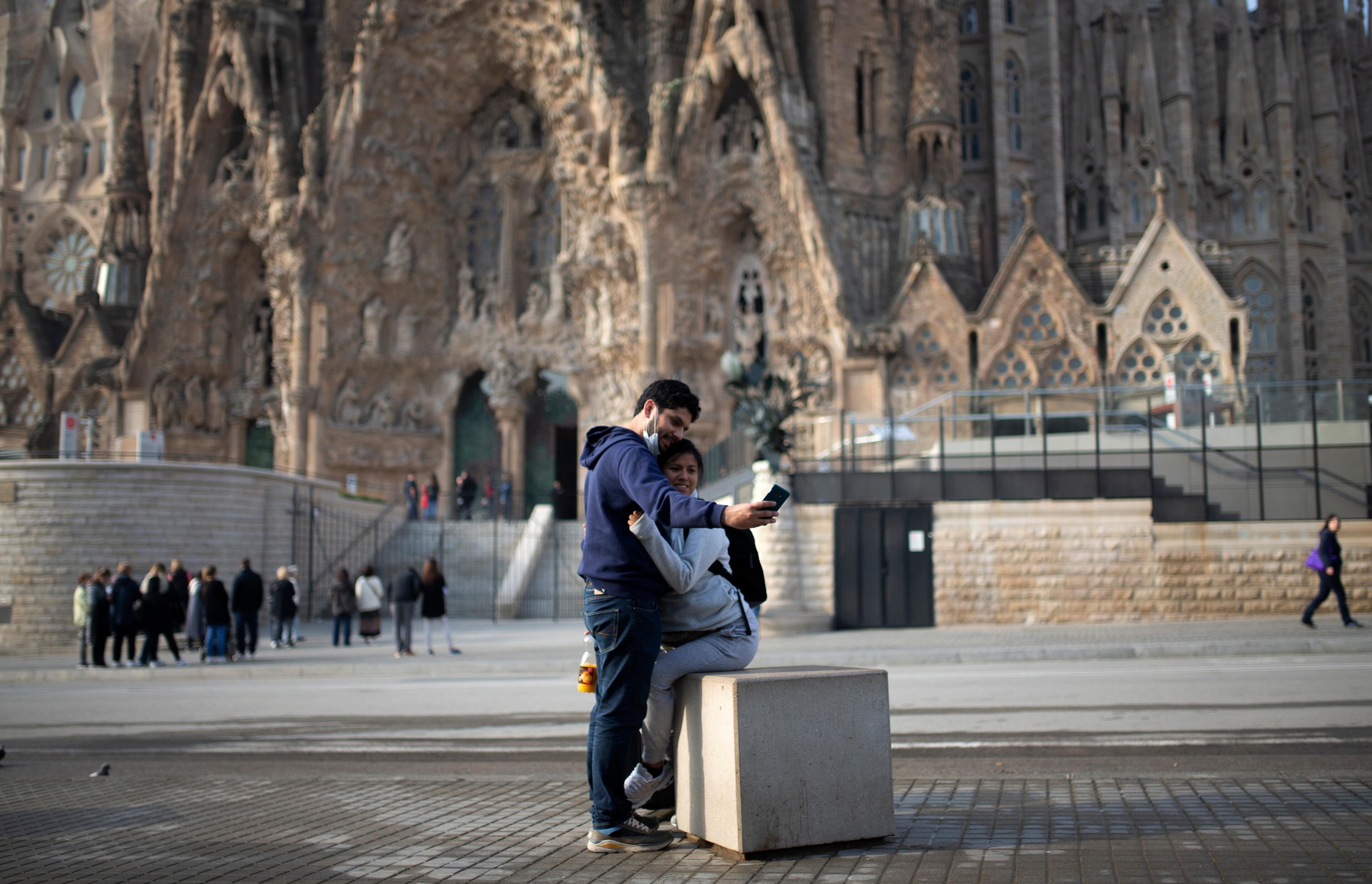 People take a selfie outside the Sagrada Familia basilica in Barcelona, Spain, Friday, March 13, 2020. The basilica closed its doors to visitors and suspend construction from Friday, March 13 to prevent the spread of the new COVID-19 coronavirus. Spain, along with Italy and France, is among the countries worst hit by the virus so far in Europe. For most people, the new coronavirus causes only mild or moderate symptoms. For some it can cause more severe illness. (AP Photo/Joan Mateu)