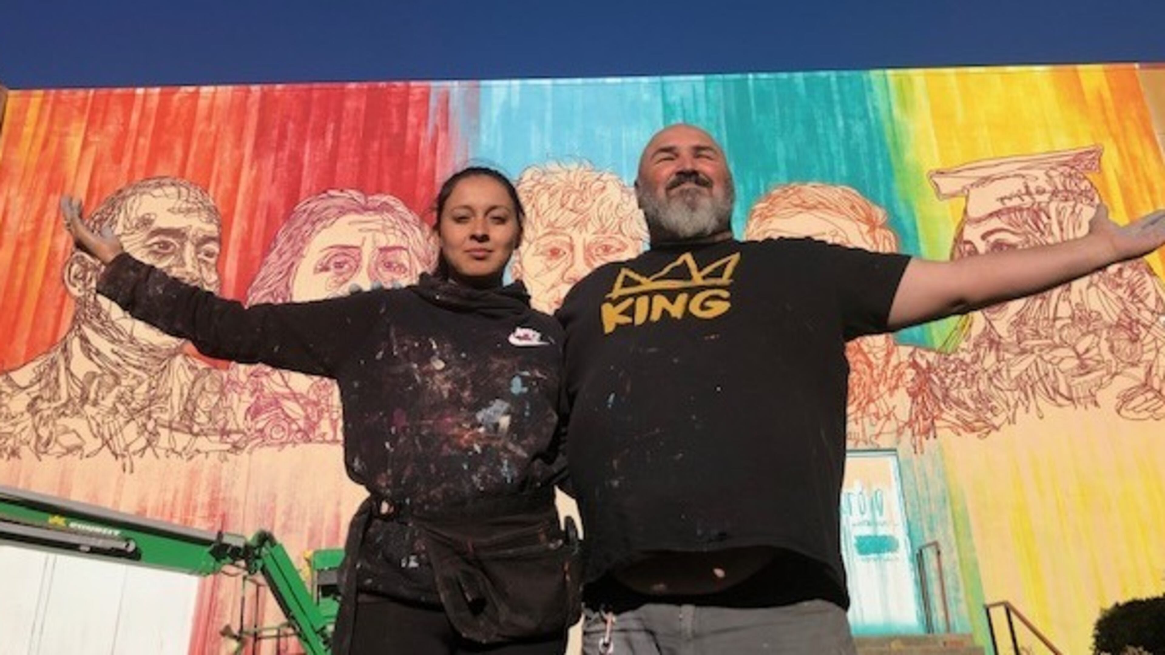 Yehimi Cambrón (left) and fellow muralist Joe Dreher stand outside Cambron's new mural, "Mi Gente," which Dreher helped paint. CONTRIBUTED: ATLANTA HISTORY CENTER