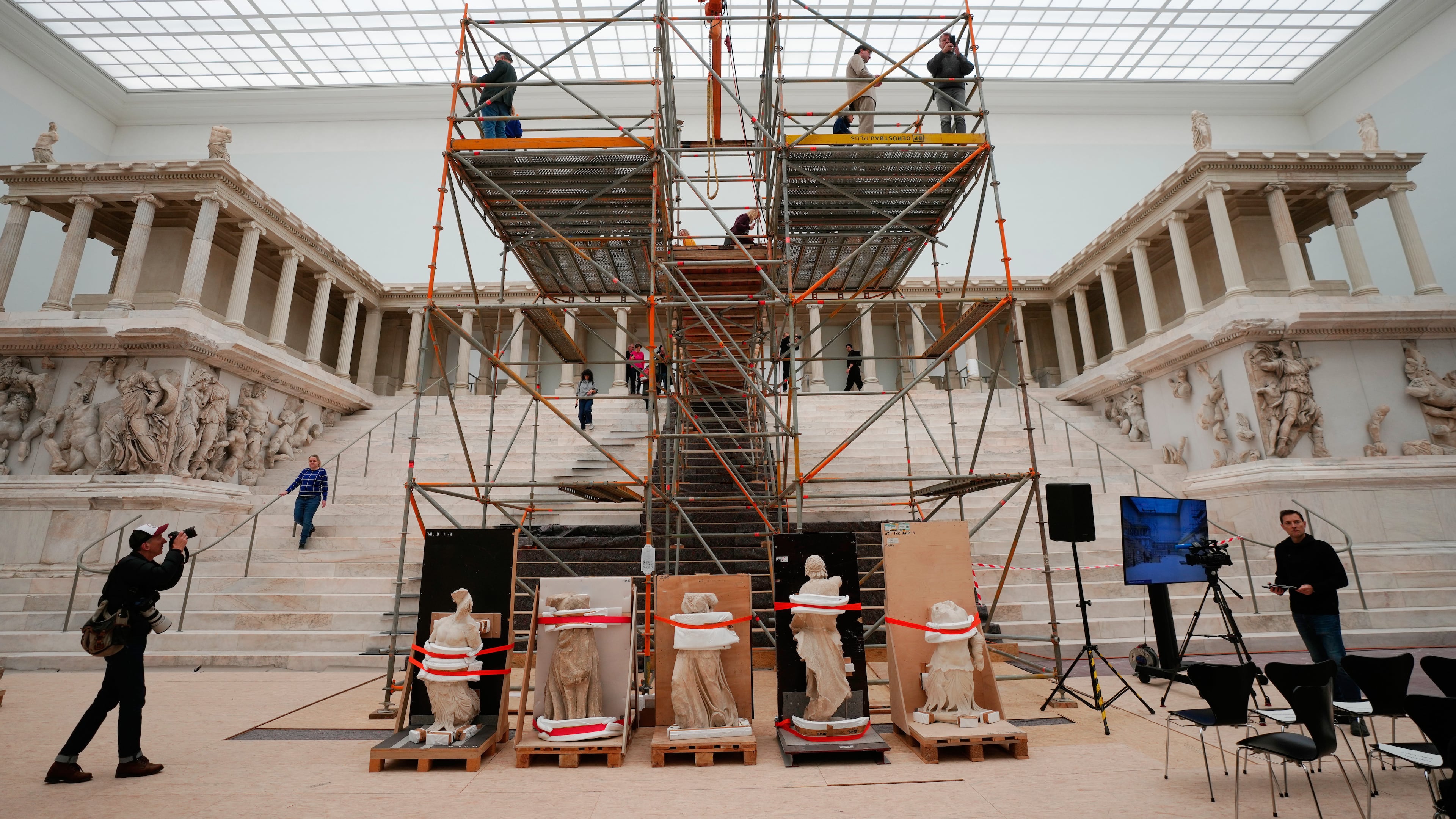 FILE - Journalists look at the Great Altar of Pergamon, during a press tour of the renovation construction site of the Pergamon Museum in Berlin, Germany, Dec. 4, 2025. (AP Photo/Markus Schreiber, File)