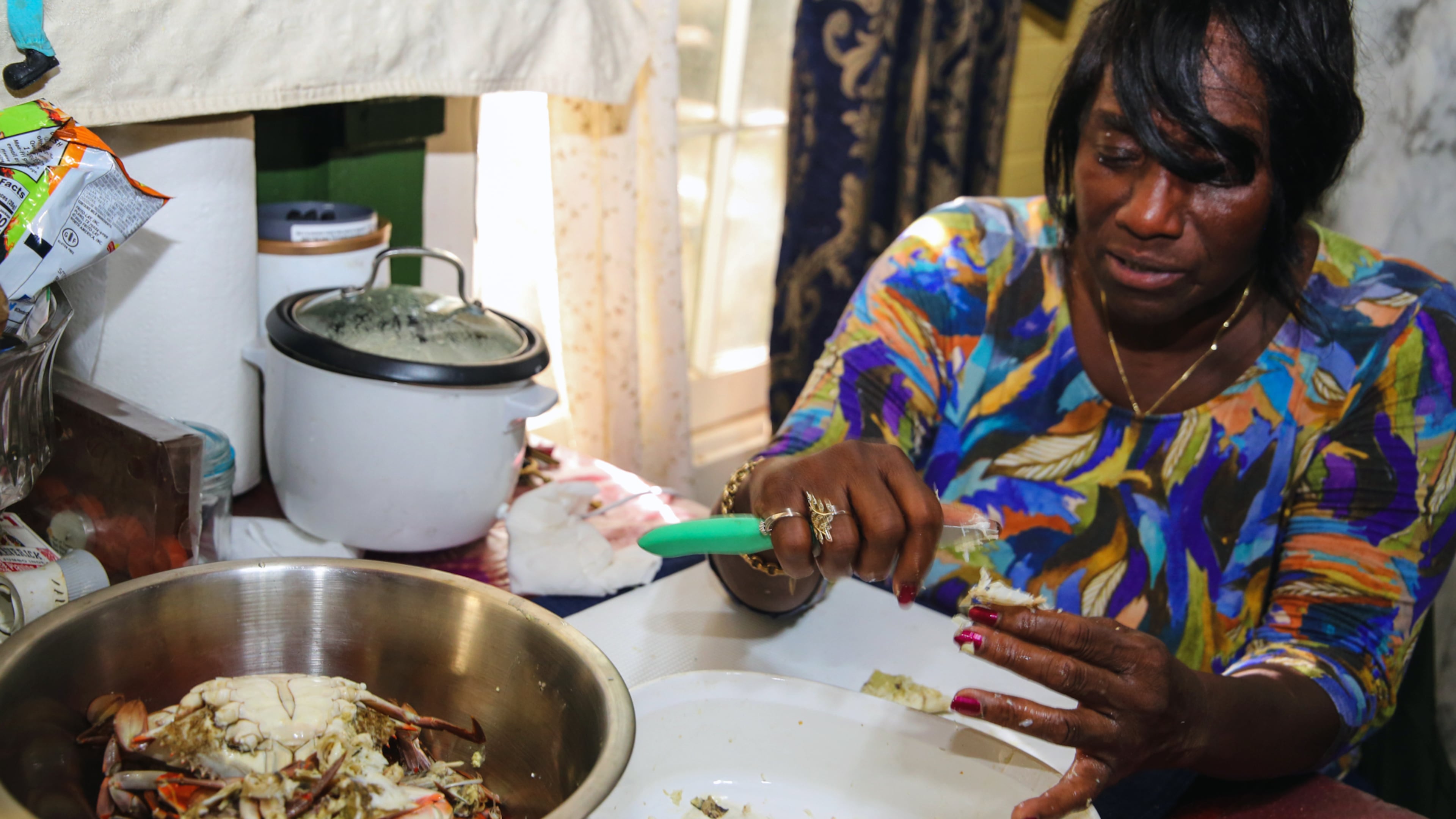 With practiced hands, chef and author Sallie Ann Robinson swiftly picks the sweet, tender crab meat from the legs and shells, showcasing her expertise and the efficiency honed by generations of island cooking in a photo from 2024. (Adriana Iris Boatwright for The Atlanta Journal-Constitution)