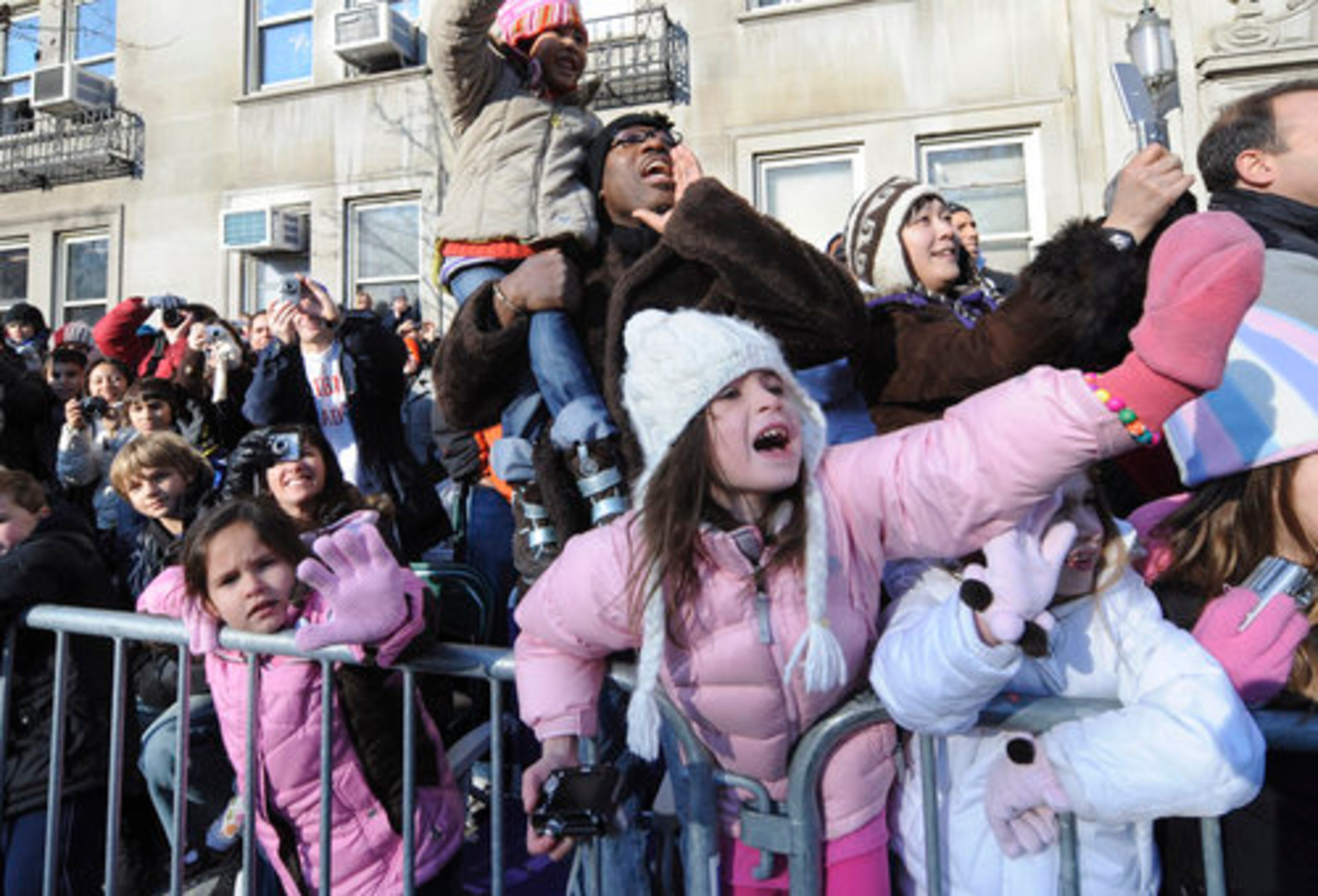 The crowd reacts to Miley Cyrus passing by aboard the "Bolt" float.