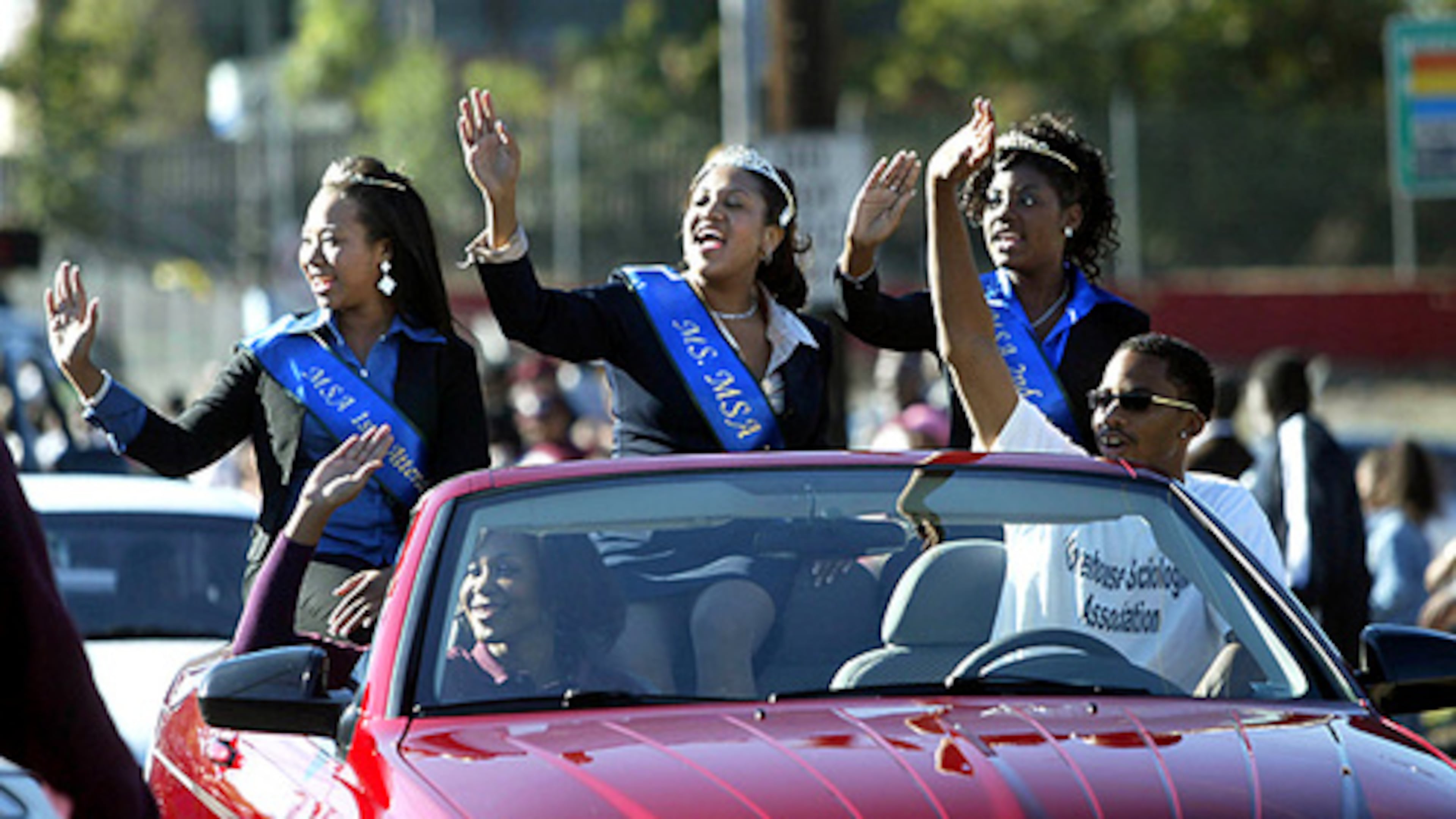 Members of the Morehouse College Sociological Association wave to spectators as they drive down Joseph E. Lowery Boulevard during the Morehouse Homecoming Parade. (From left) Melanie Harris, first attendant, Gimel Rogers, queen, and Qivon Annan, second attendant enjoy the college's homecoming. (Jason Getz/AJC FILE)