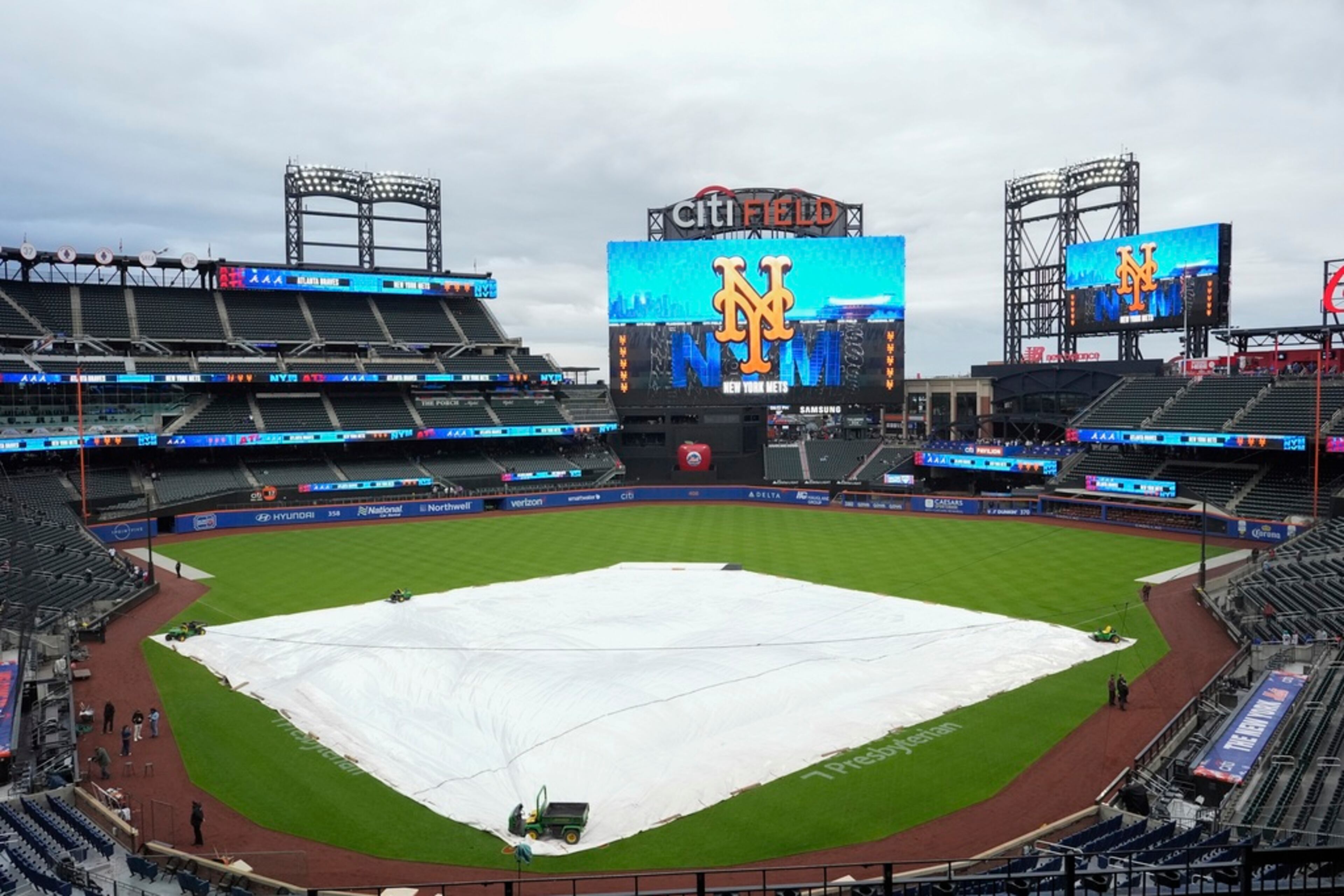 A tarp covers the infield at Citi Field as rain has delayed the start of a baseball game between the New York Mets and the Atlanta Braves, Friday, May 10, 2024, in New York. (AP Photo/Frank Franklin II)