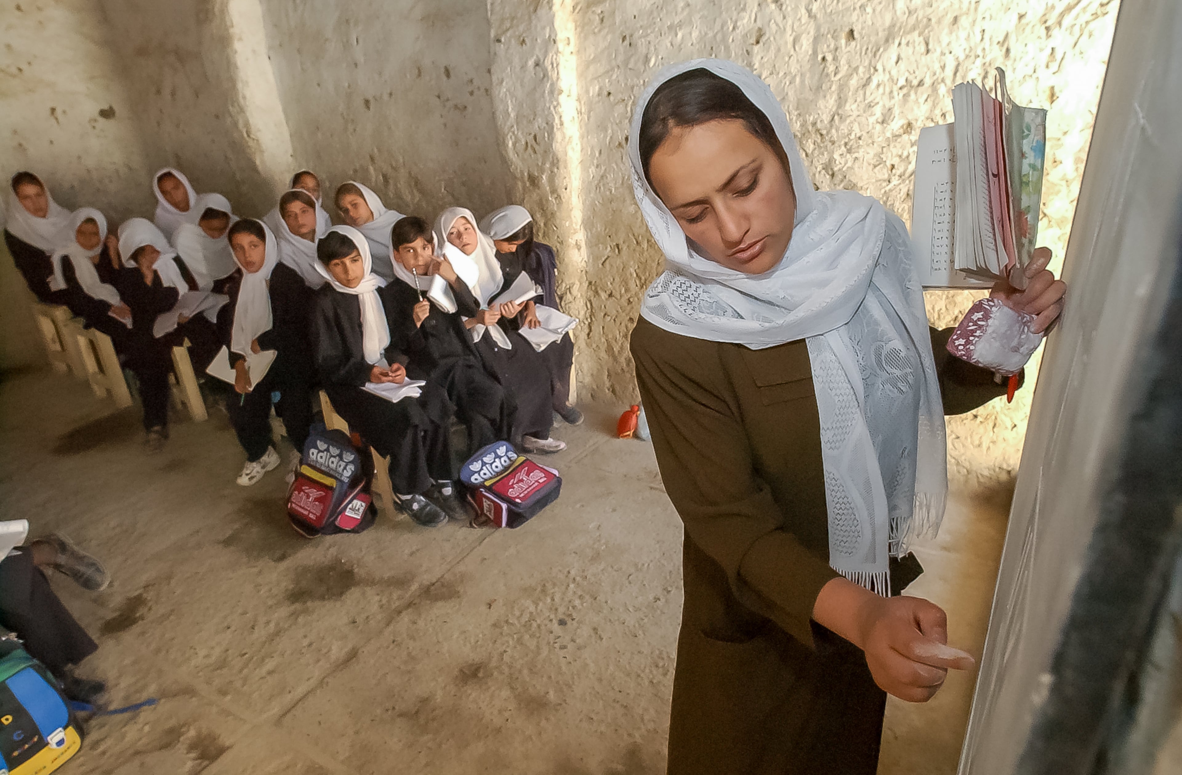 KABUL, AFGHANISTAN: Teacher Najiba, 27, writes math problems on the board for her third-grade students at the Naswan Manochary girls' school in Kabul Sunday 9/15/2002. (Bita Honarvar / The Atlanta Journal-Constitution)