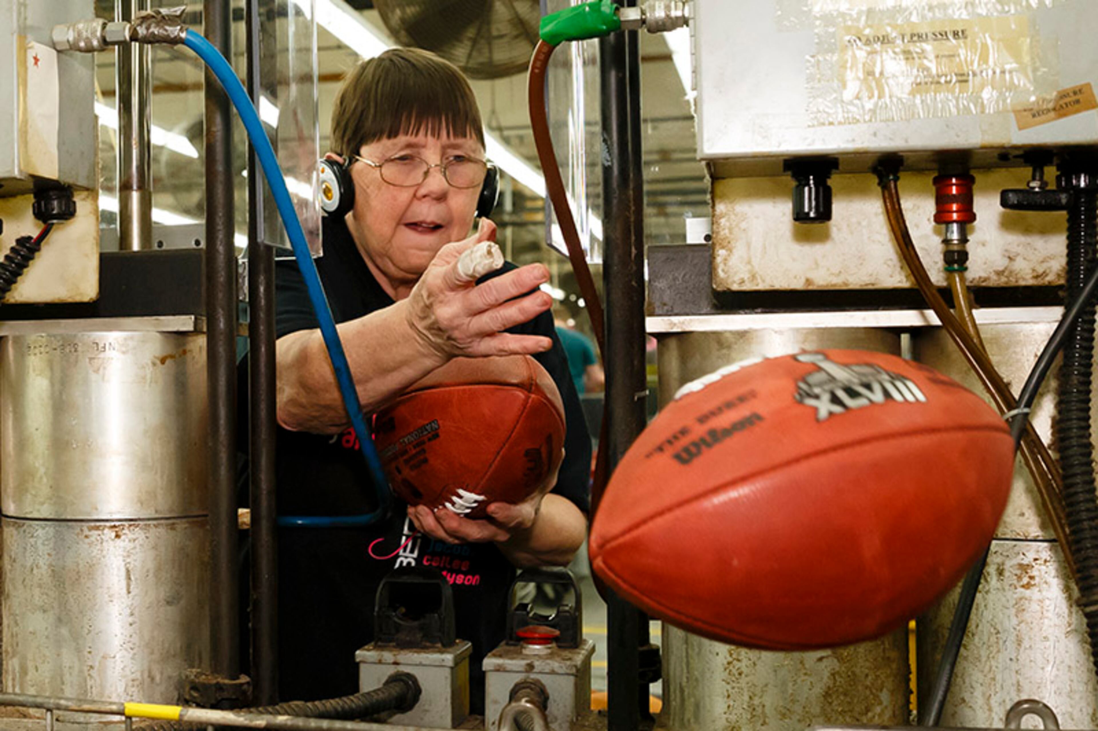 Deb Connelly is among to fling the official Super Bowl XLVIII ball into action as it moves down the production line to final shipping.