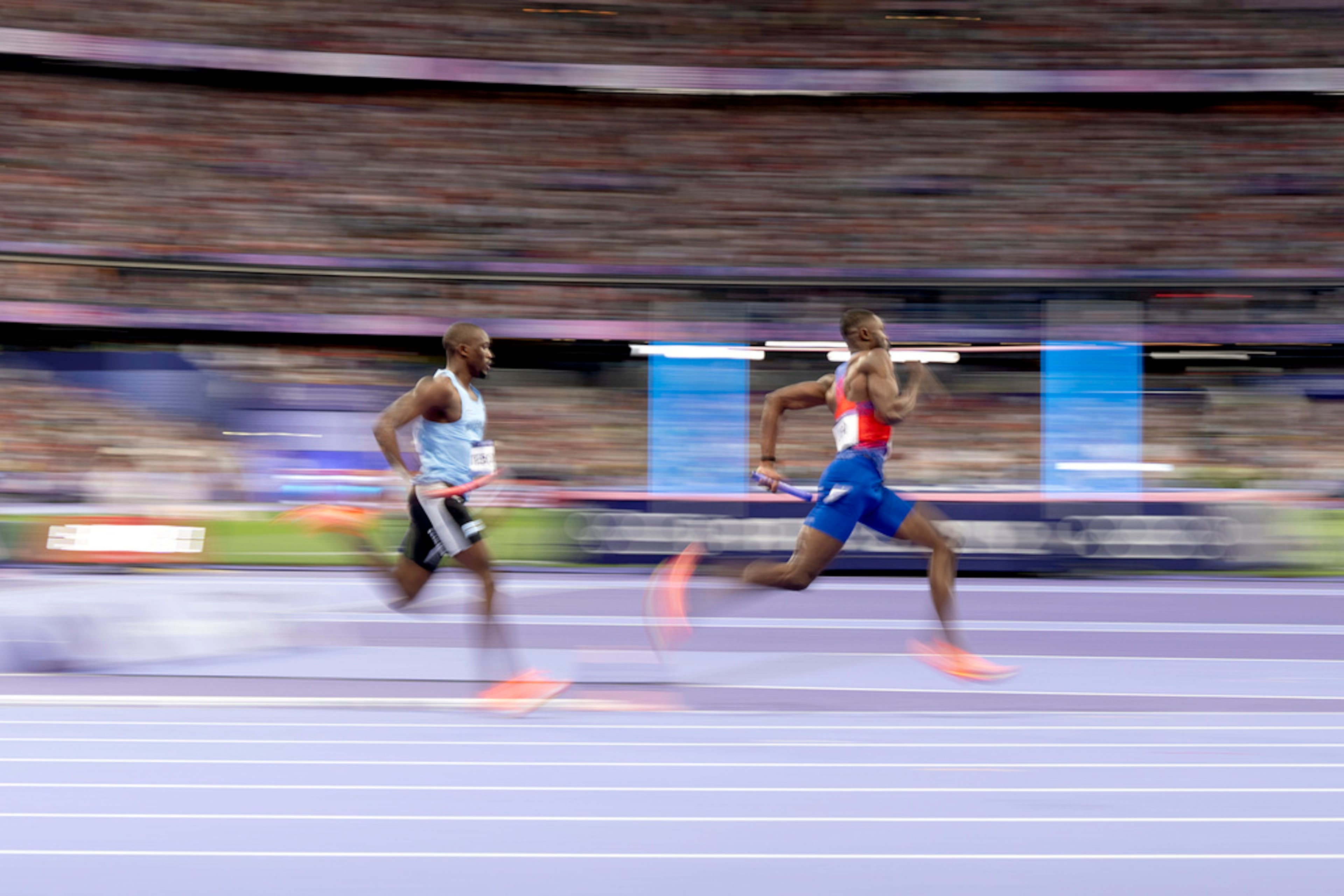 The United States' Rai Benjamin runs ahead of Botswana's Letsile Tebogo during the men's 4 x 400 meters relay final at the 2024 Summer Olympics, Saturday, Aug. 10, 2024, in Saint-Denis, France. (AP Photo/David Goldman)
