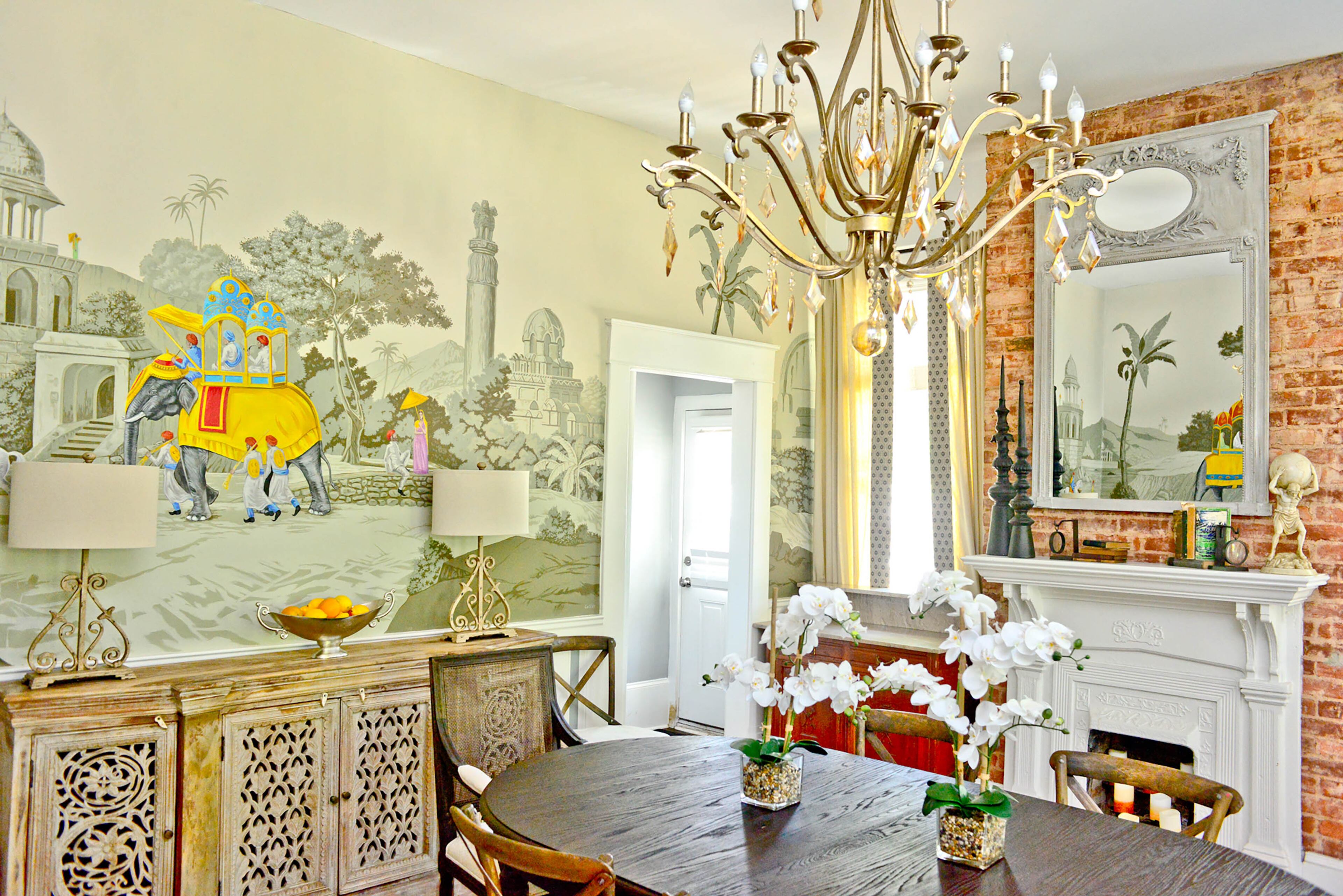 The dining room features one of the home's original fireplaces, along with a table and chairs from RH, amid the backdrop of an original mural by artist Michael Colley. Amanda and Philippe Pellerin have hosted neighborhood events to re-introduce the Grant Park belle to the community, including the 43rd Grant Park Spring Tour of Homes. Text by Lori Johnston and Keith Still/Fast Copy News Service.
