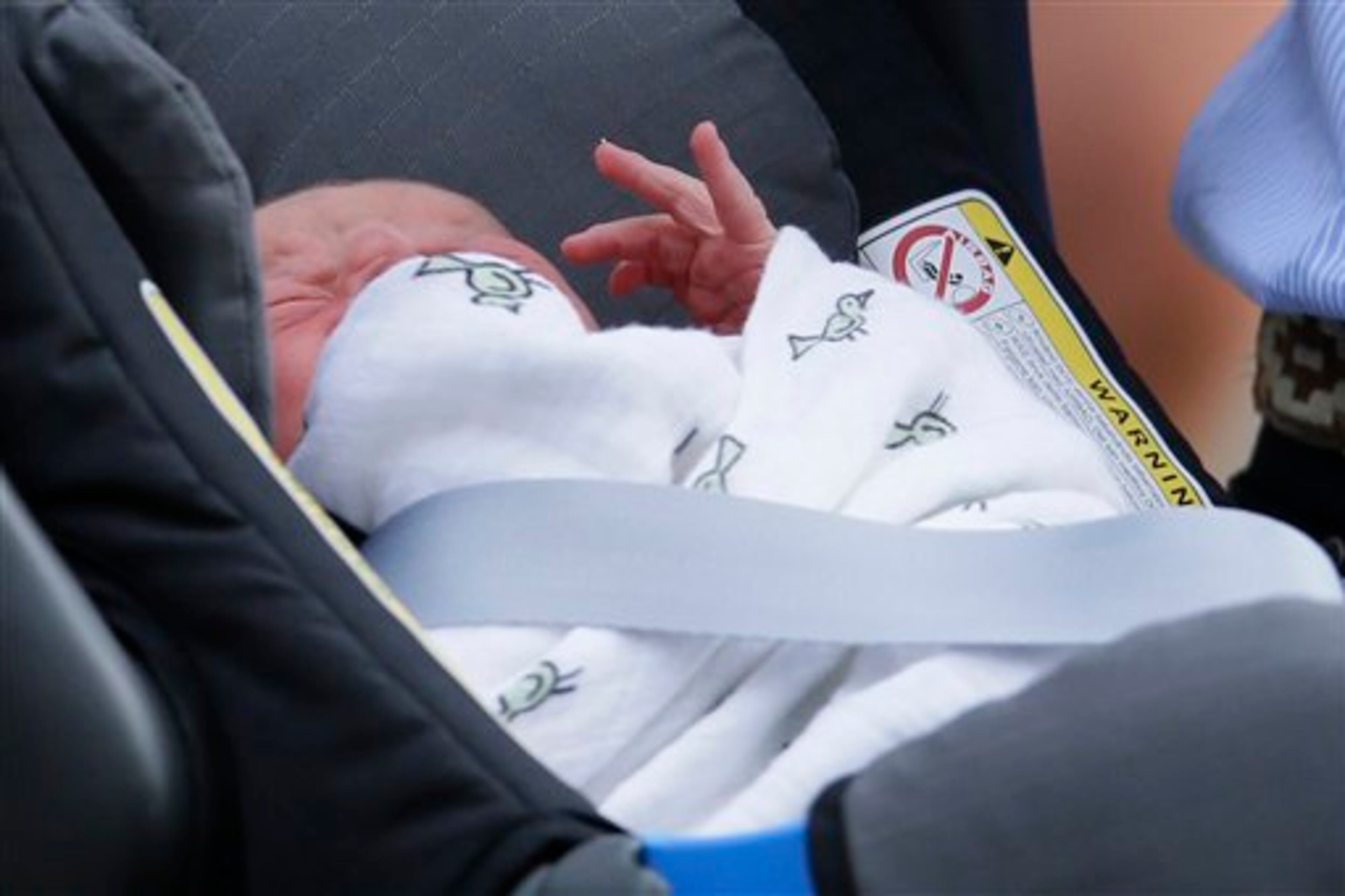 The Prince of Cambridge lays in a car seat as his parents, Britain's Prince William and Kate, Duchess of Cambridge leave St. Mary's Hospital exclusive Lindo Wing, Tuesday July 23, 2013, in London where the Duchess gave birth on Monday July 22. The Royal couple are expected to head to London�s Kensington Palace from the hospital with their newly born son, the third in line to the British throne. (AP Photo/Alastair Grant)
