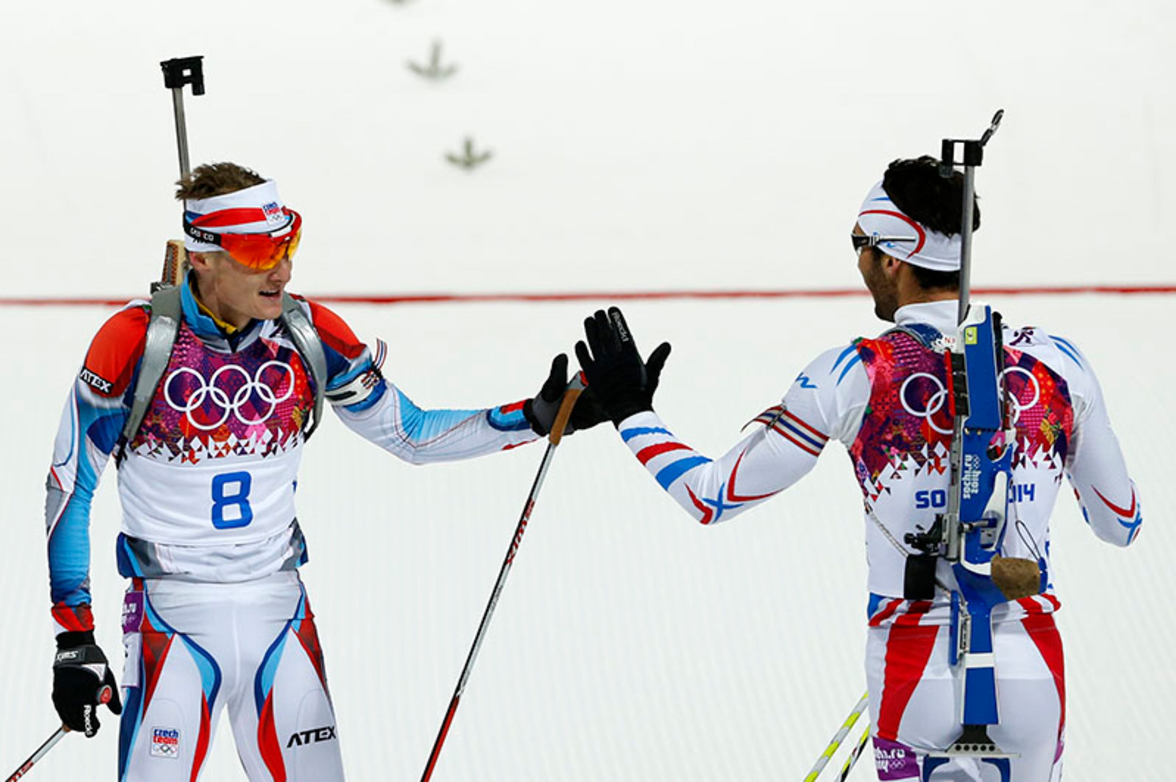 France's gold medal winner Martin Fourcade, right, congratulates Czech Republic's silver medal winner Ondrej Moravec after crossing the finish line of the men's biathlon 12.5k pursuit, at the 2014 Winter Olympics, Monday, Feb. 10, 2014, in Krasnaya Polyana, Russia.