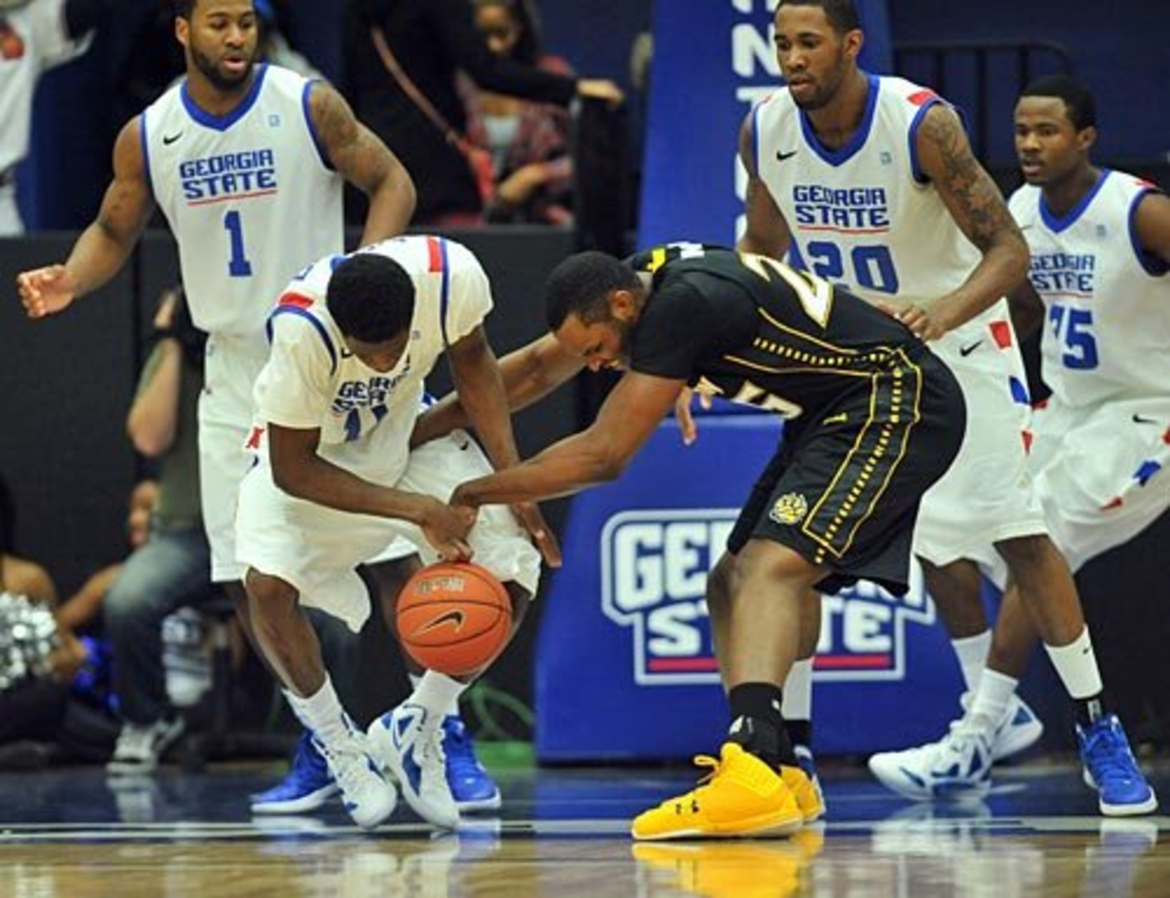 Georgia State guard Tony Kimbro Jr. (11) and Towson forward Robert Nwankwo (25) fight for a loose ball under the basket.