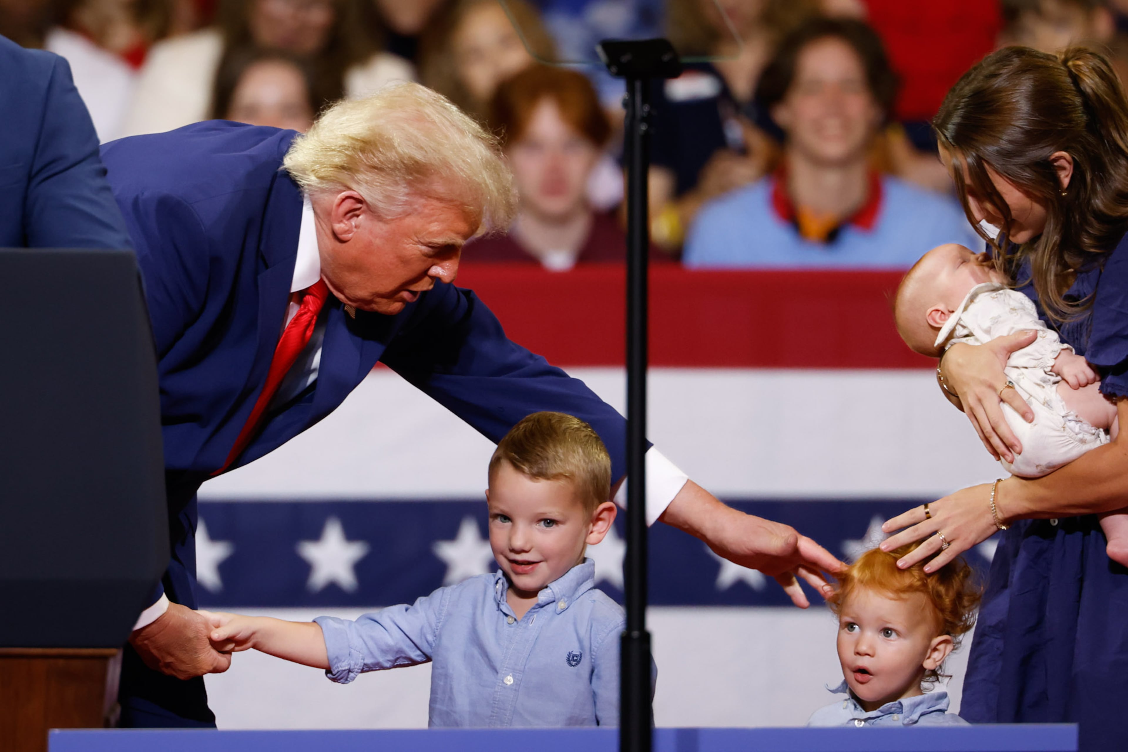 President Donald Trump greets members of the Loden family, who signed up for Trump Accounts, during his rally at Wheeler High School in Marietta on July 22, 2026. (Arvin Temkar/AJC)