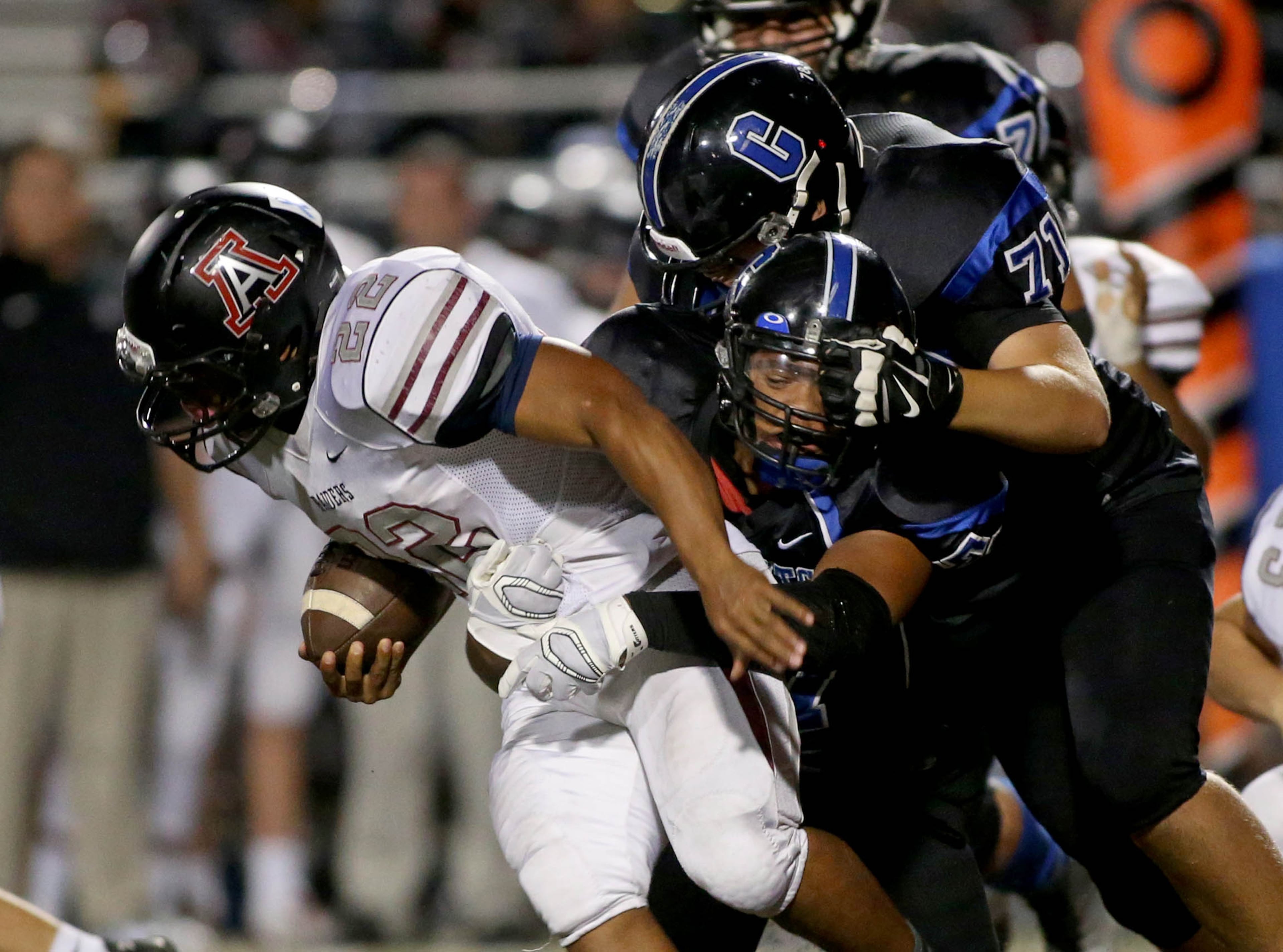 Alpharetta running back Lemuel Cobbs (22) is tackled for a short gain by Centennial defenders in the second half of their game Friday at Centennial High School in Roswell, Ga., October 10, 2014. Alpharetta won 39-0. JASON GETZ / SPECIAL
