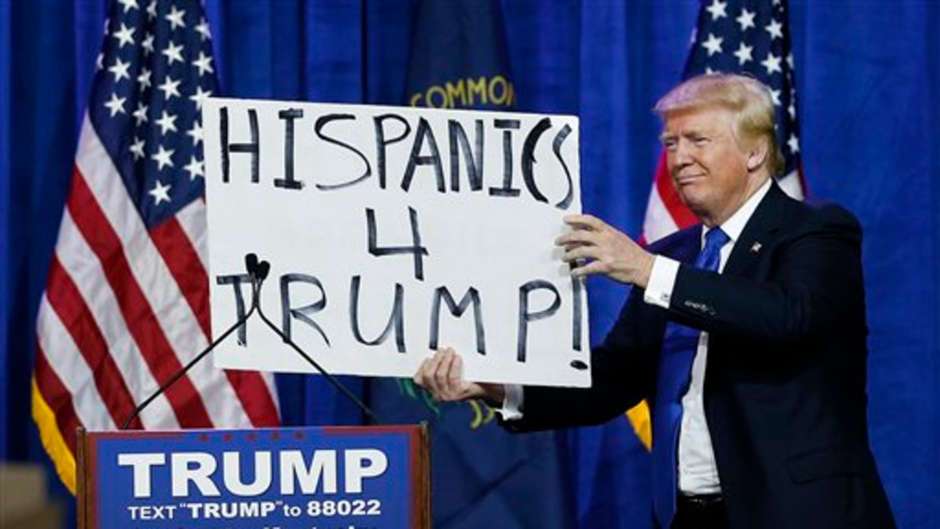 Republican presidential candidate Donald Trump holds up a sign he borrowed from a spectator during a rally Tuesday, March 1, 2016, in Louisville, Ky. (AP Photo/John Bazemore)