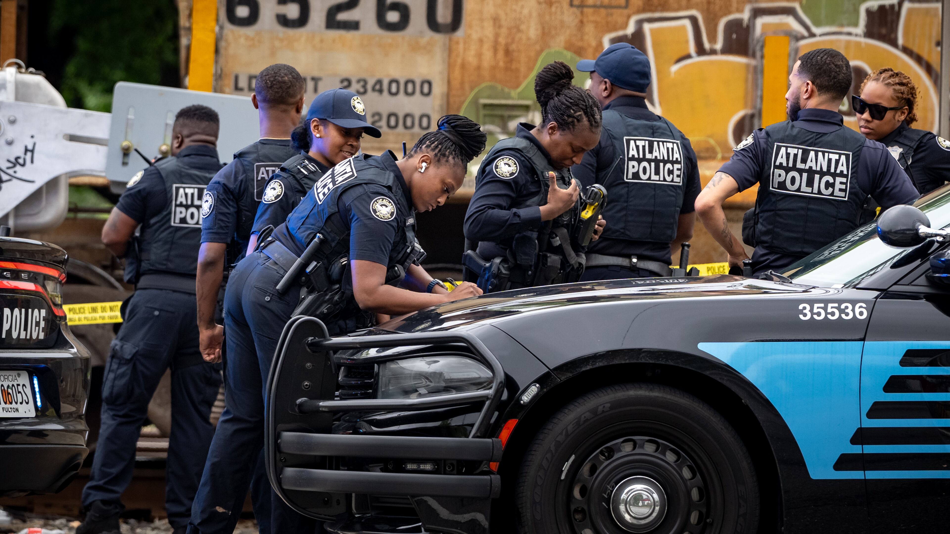 Atlanta police are seen assisting Norfolk Southern police after a woman was killed by a train in southwest Atlanta on Monday.