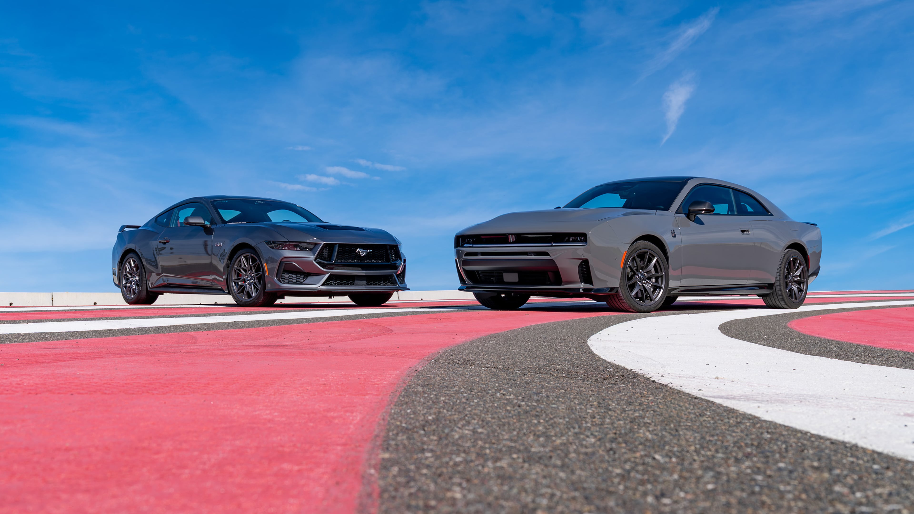 This photo provided by Edmunds shows the newest Dodge Charger and Ford Mustang, historic rivals. (Courtesy of Edmunds via AP)