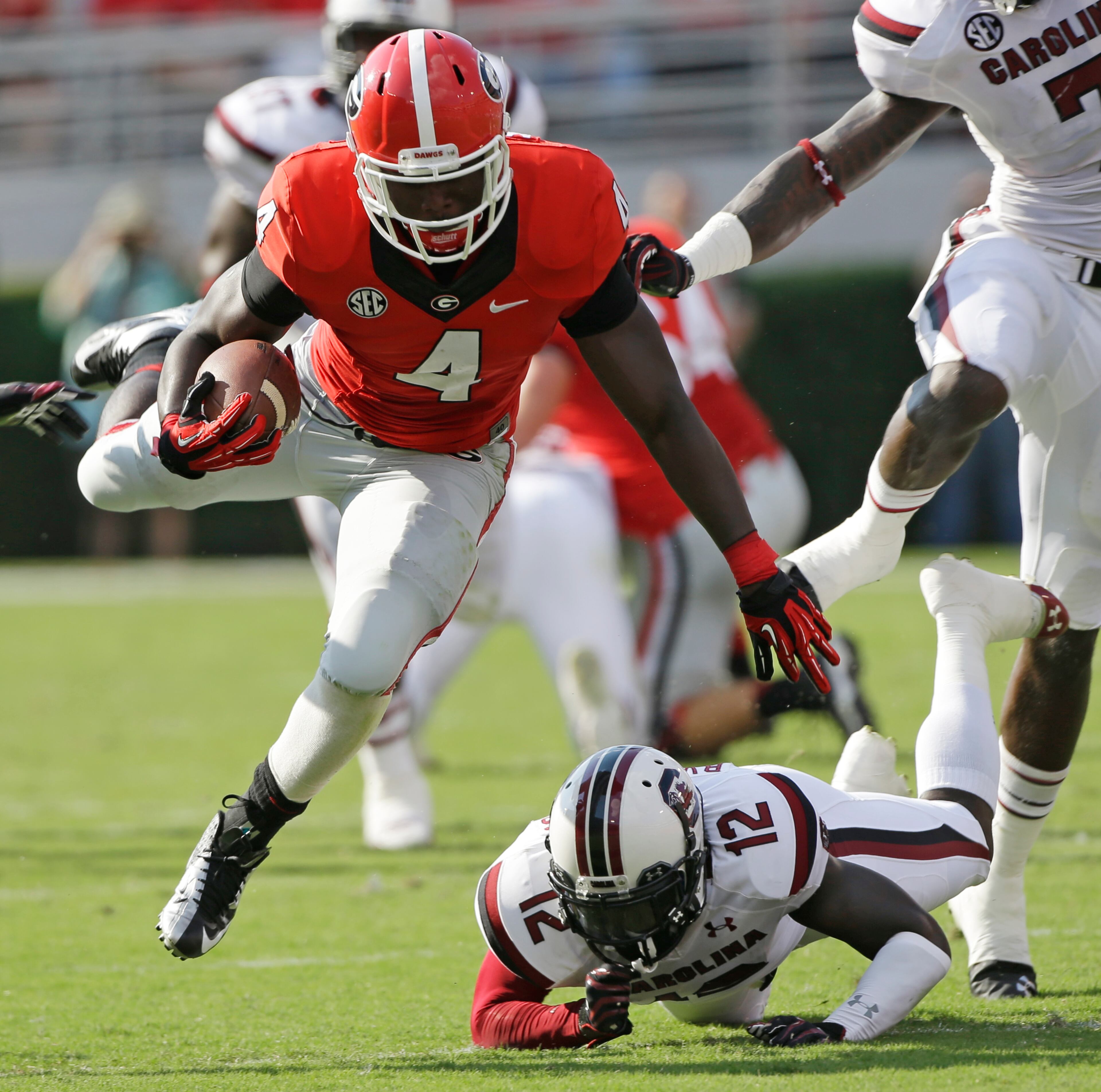 Keith Marshall (4) gets by South Carolina safety Brison Williams (12).