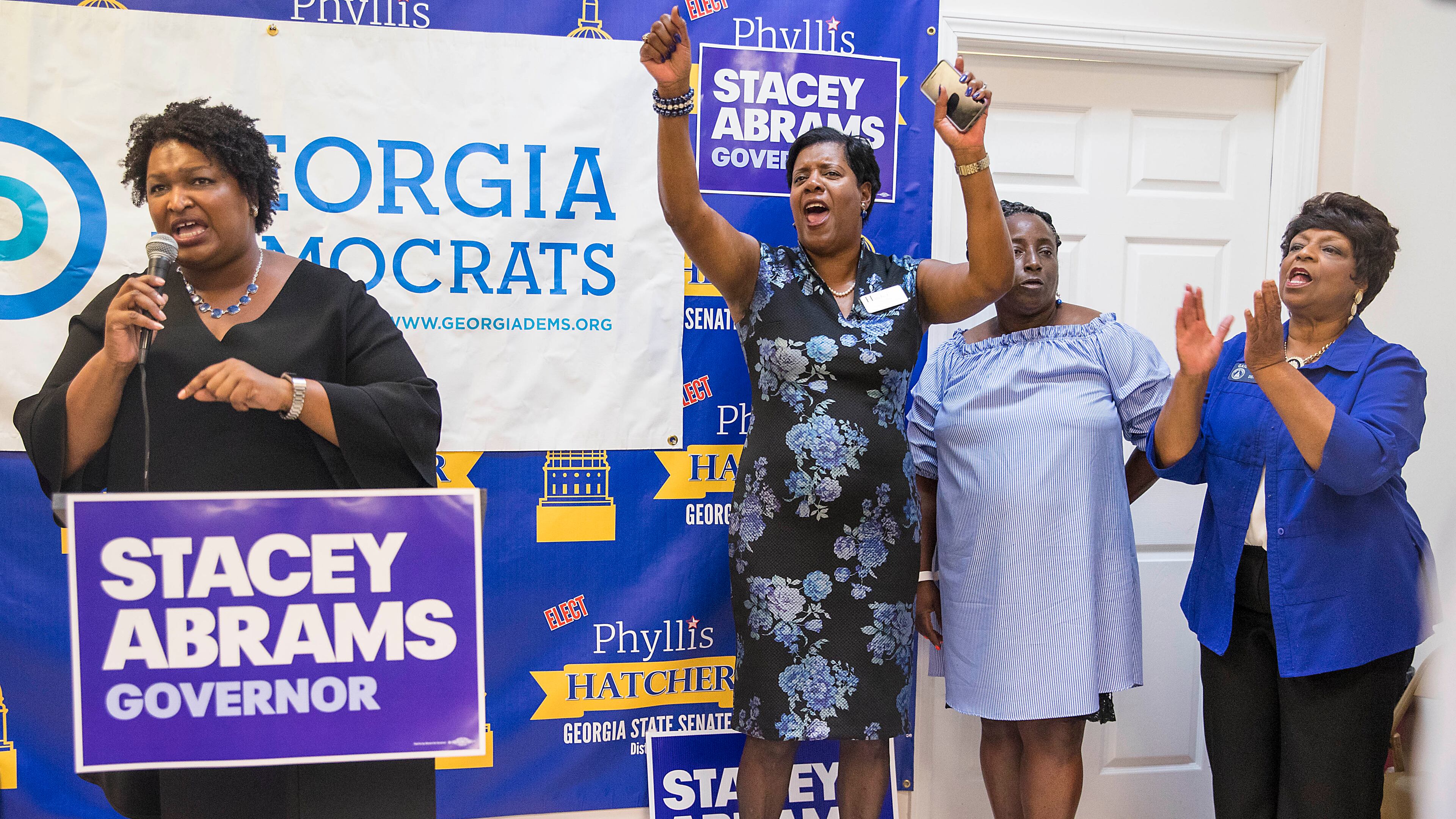 08/17/2018 -- Atlanta, Georgia -- While giving a speech, Georgia Gubernatorial Democratic candidate Stacey Abrams (left) is cheered on by Georgia State Senate District 17 candidate Phyllis Hatcher (clockwise) Georgia House Representative Sandra Scott (D) (second from right) and Georgia District 44 State Senator Gail Davenport (D) (right), during a Jobs Town Hall at the South Metro/Henry County Democratic field office in McDonough, Friday, August 17, 2018. (ALYSSA POINTER/ALYSSA.POINTER@AJC.COM)