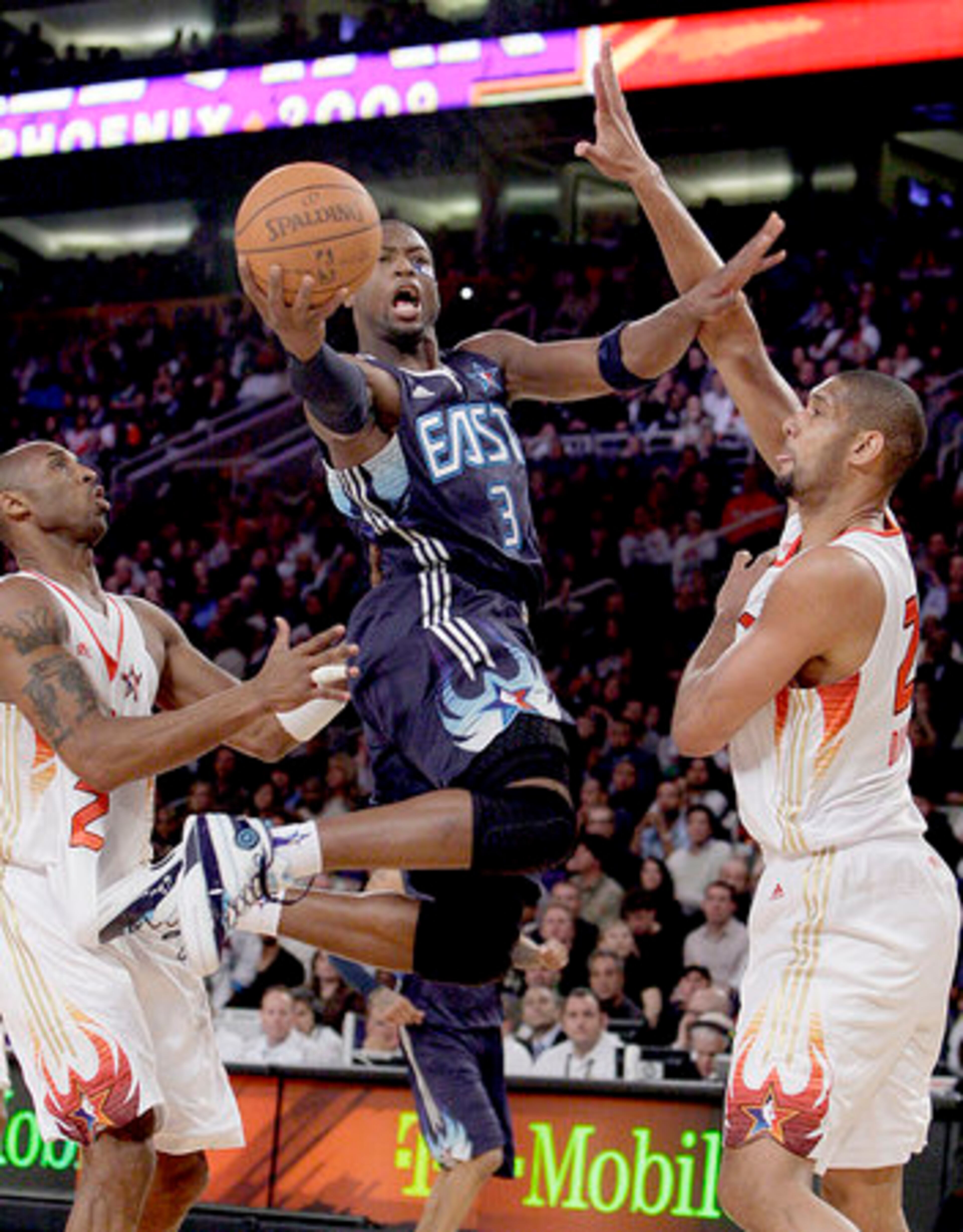 Eastern All-Star guard Dwyane Wade (3) of the Miami Heat goes to the basket between Western All-Stars Kobe Bryant (24), of the Lakers, and Tim Duncan (21), of the Spurs.