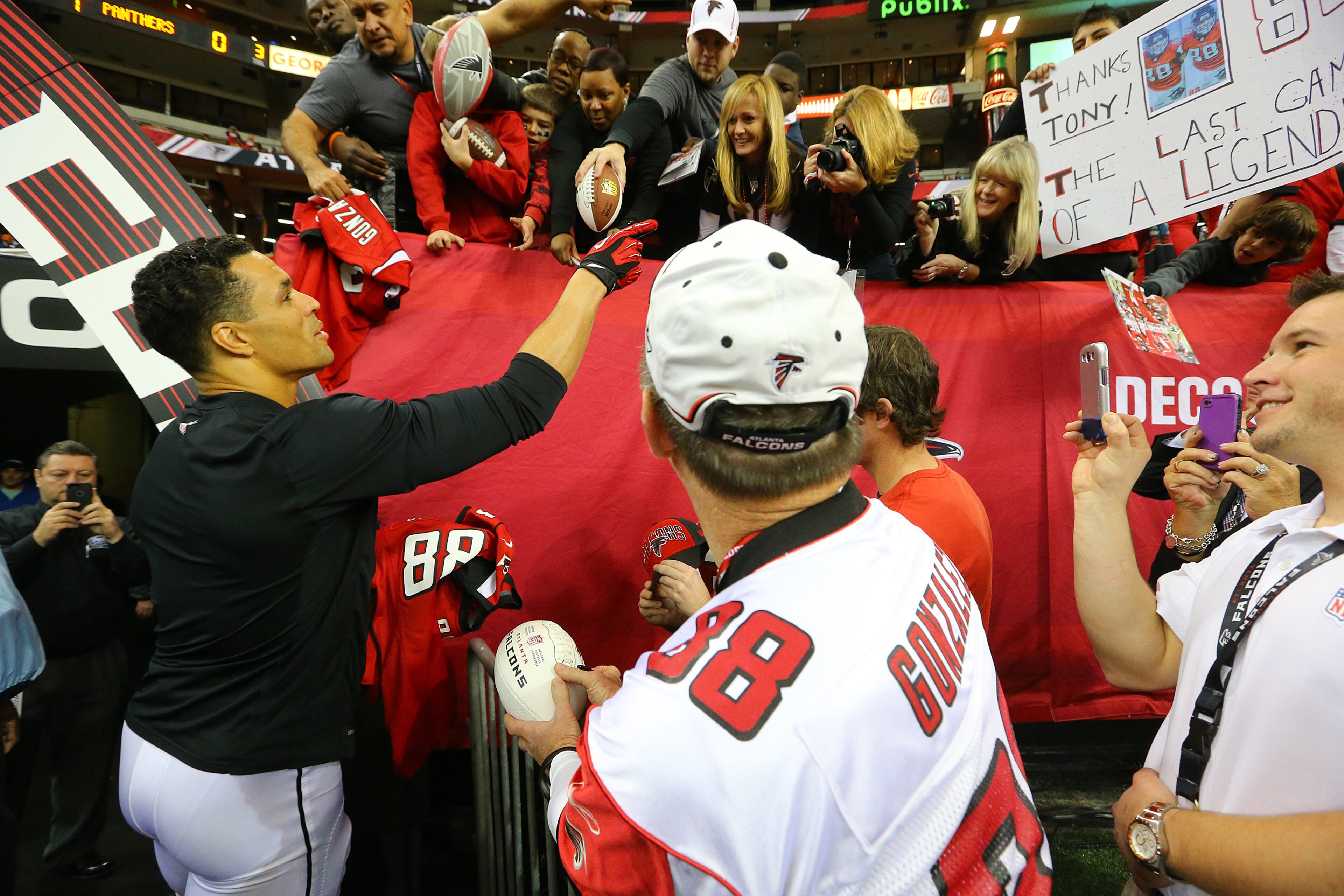 Falcons tight end Tony Gonzalez signs autographs for fans before playing the final game of his 17-year NFL career on Sunday, Dec. 29, 2013, in Atlanta.