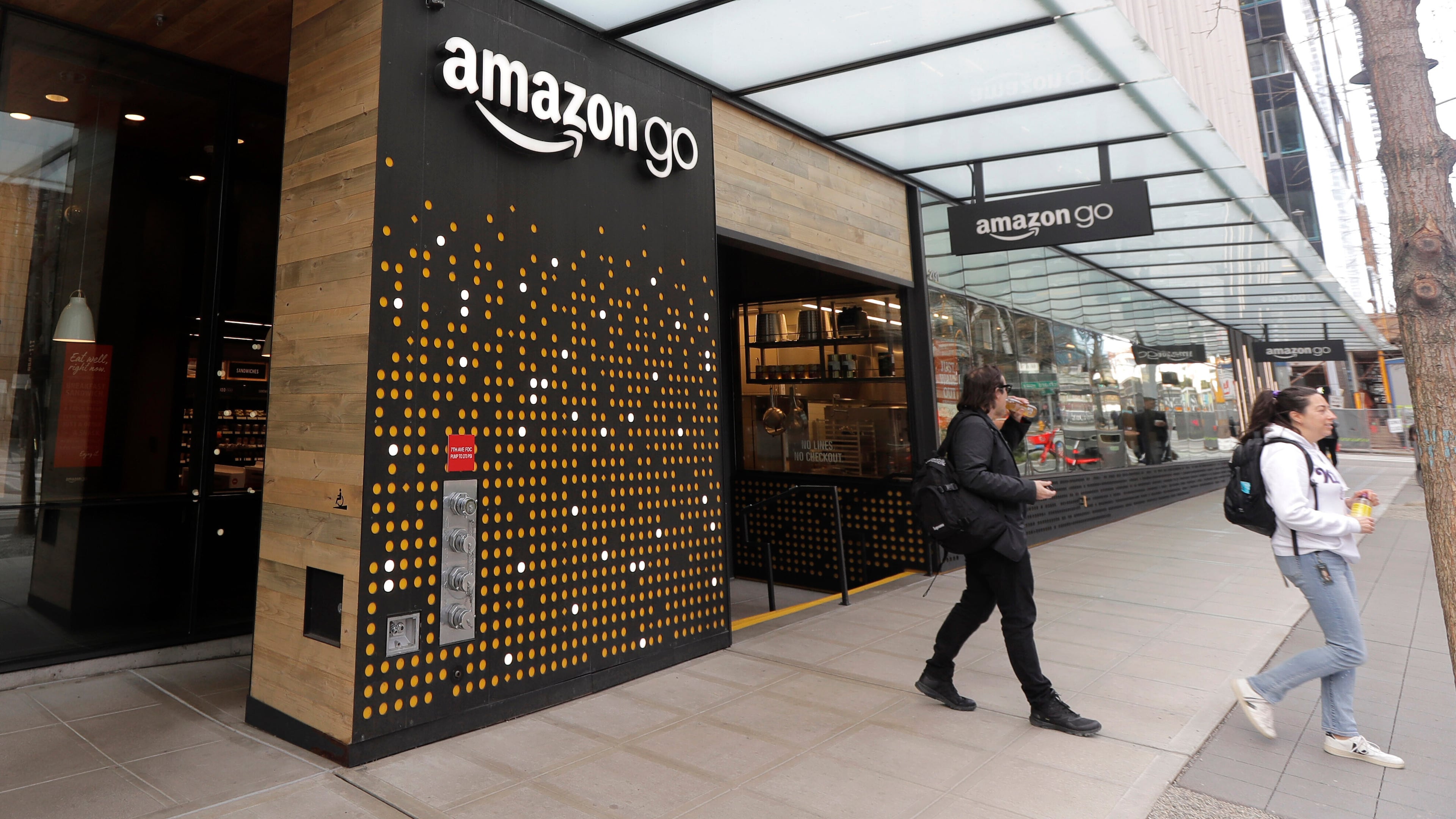 FILE - People walk out of an Amazon Go store in Seattle, March 4, 2020. (AP Photo/Ted S. Warren, File)