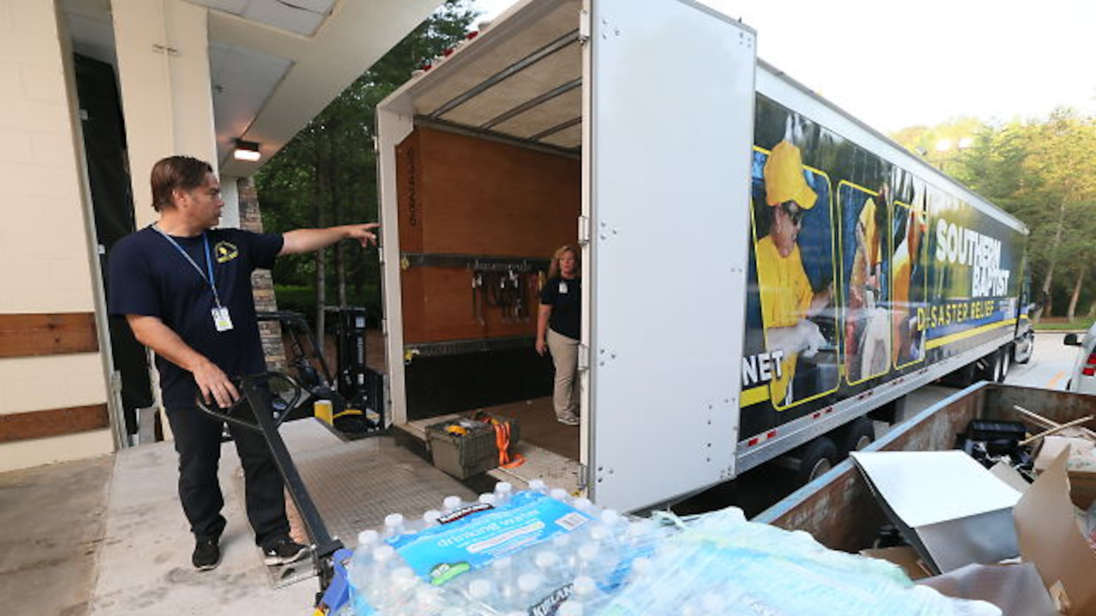 Volunteer Dan Yackel communicates with colleague Judy Cape while moving a pallet of disaster-relief supplies headed for tornado-ravaged Oklahoma.