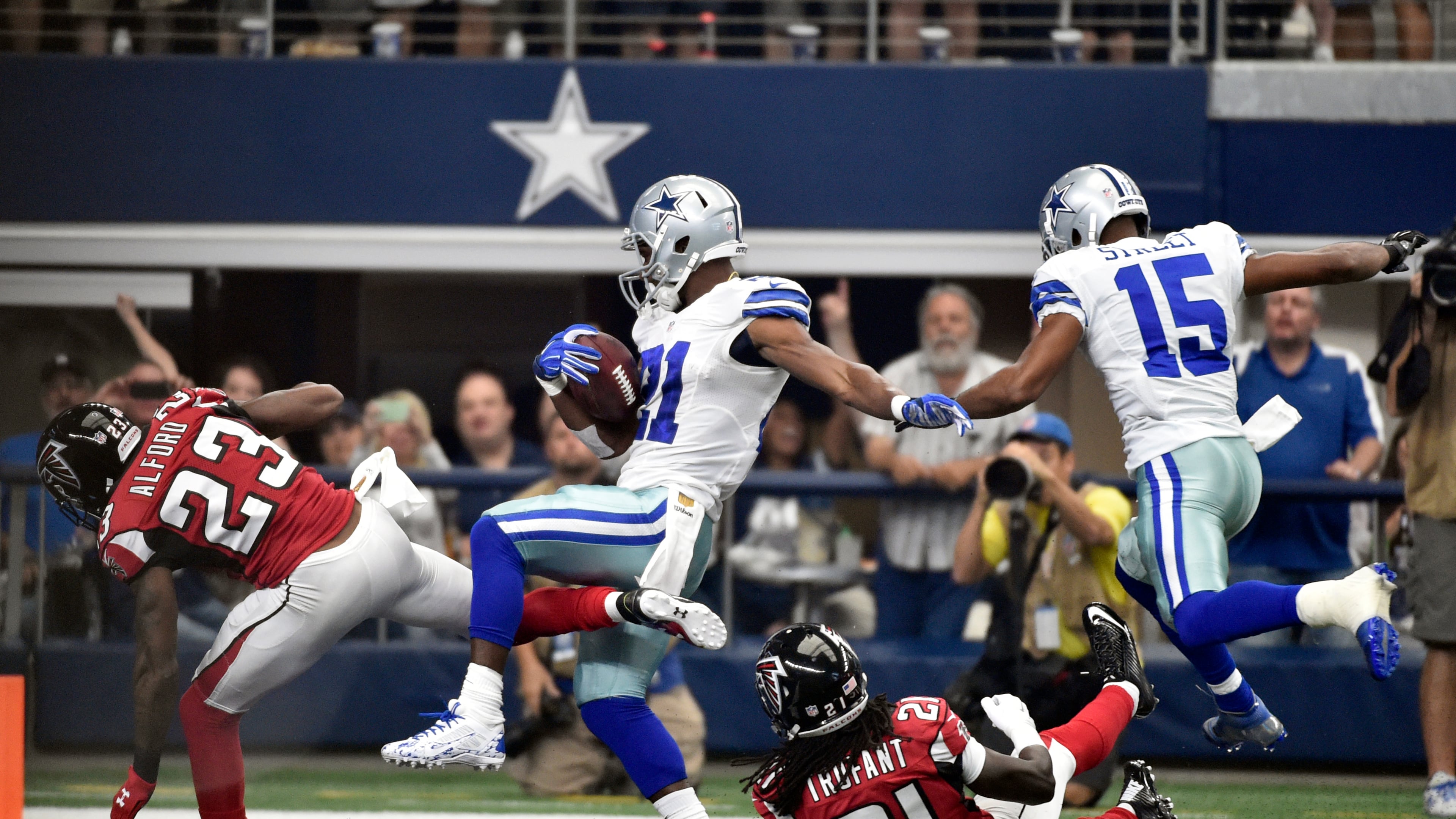 Atlanta Falcons cornerback Robert Alford (23) and cornerback Desmond Trufant (21) are sent flying along with Dallas Cowboys wide receiver Devin Street (15) as running back Joseph Randle (21) scores a touchdown on a running play during the first half of an NFL football game on Sunday, Sept. 27, 2015, in Arlington, Texas. (AP Photo/Michael Ainsworth )
