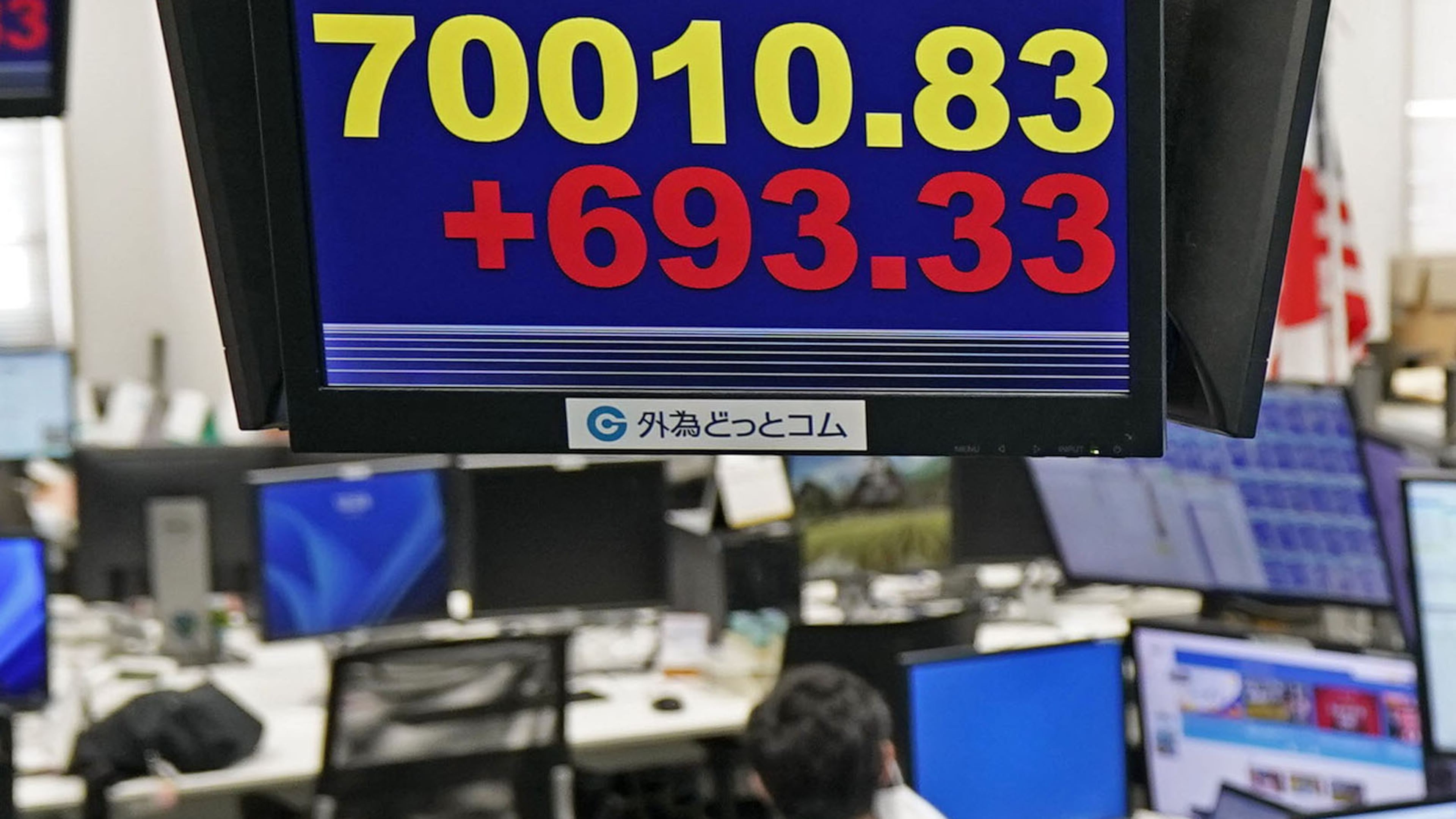 Employee of a foreign exchange dealing company work under an electronic board showing the stock index of Japan's Nikkei 225, in Tokyo Tuesday, Jun 16, 2026. (Kyodo News via AP)