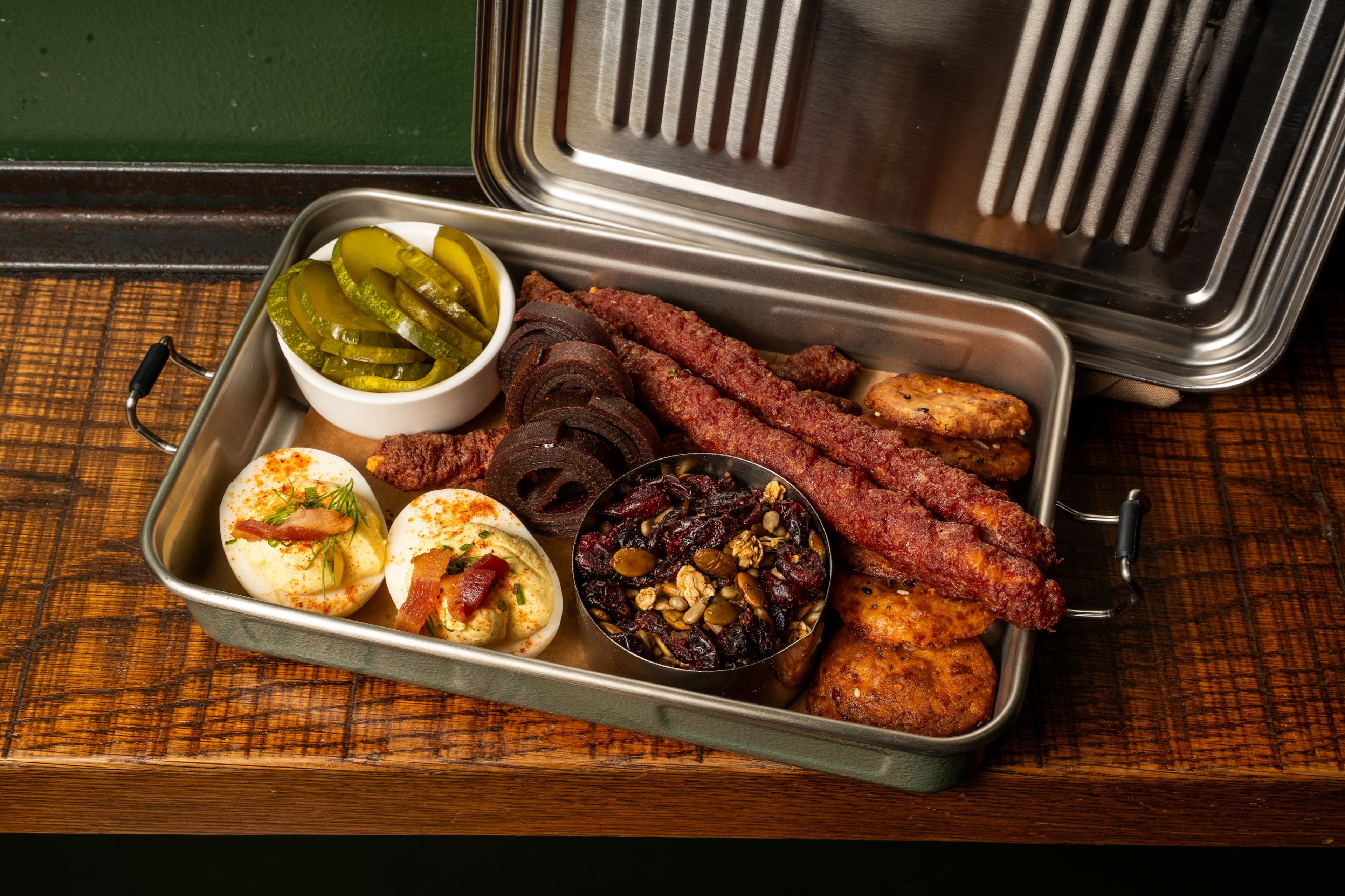 The trail pack at Ladybird, a shareable lunchbox with housemade meat sticks, cheddar crisps, pickles, deviled eggs, trail mix and a fruit roll-up. (Courtesy of Ladybird Grove & Mess Hall)