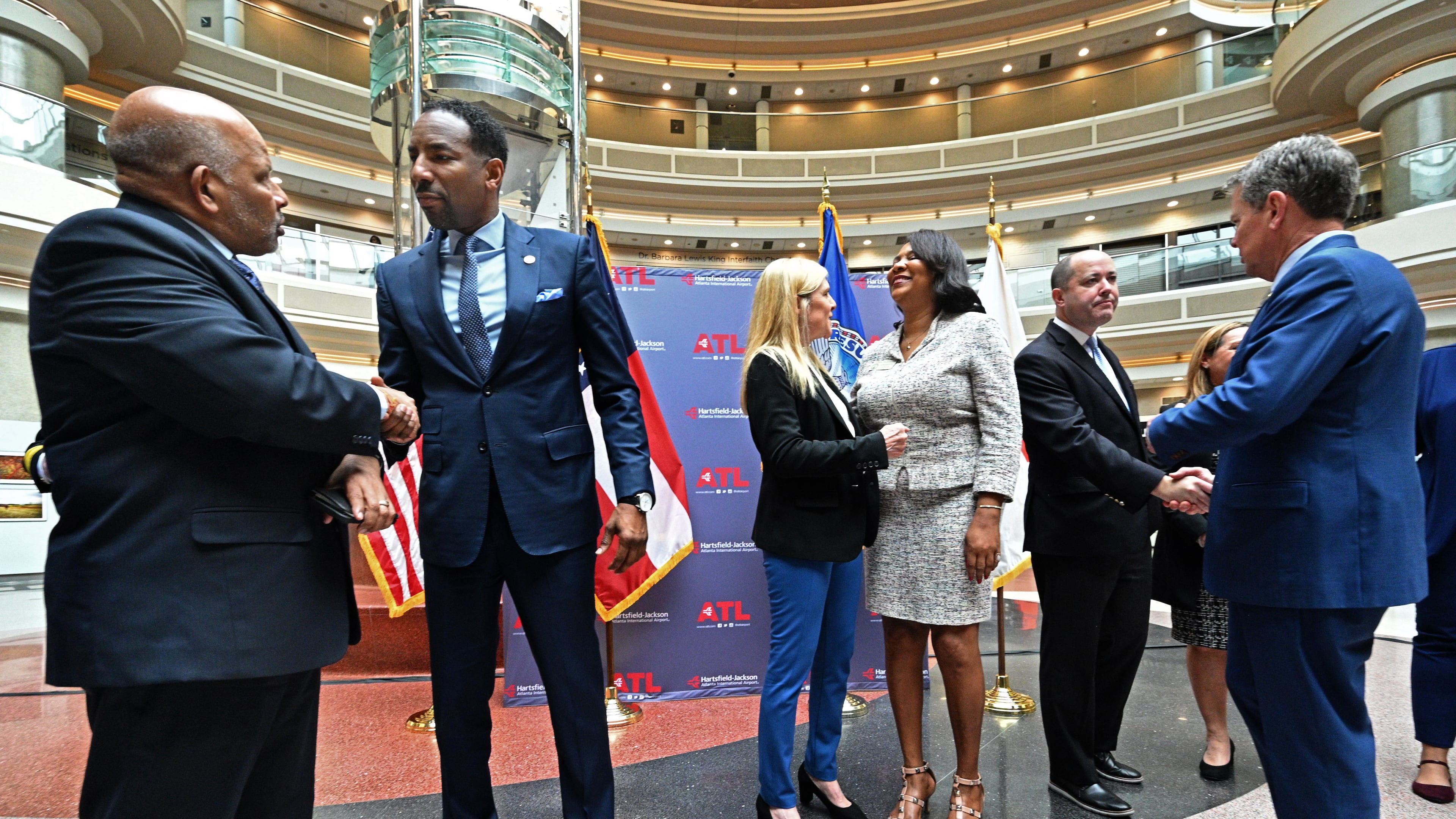 Atlanta Mayor Andre Dickens (second from left) and Governor Brian Kemp (right) greet guests after a human trafficking prevention press conference at Hartsfield-Jackson Atlanta International Airport on Jan. 31, 2023. (Hyosub Shin/AJC)