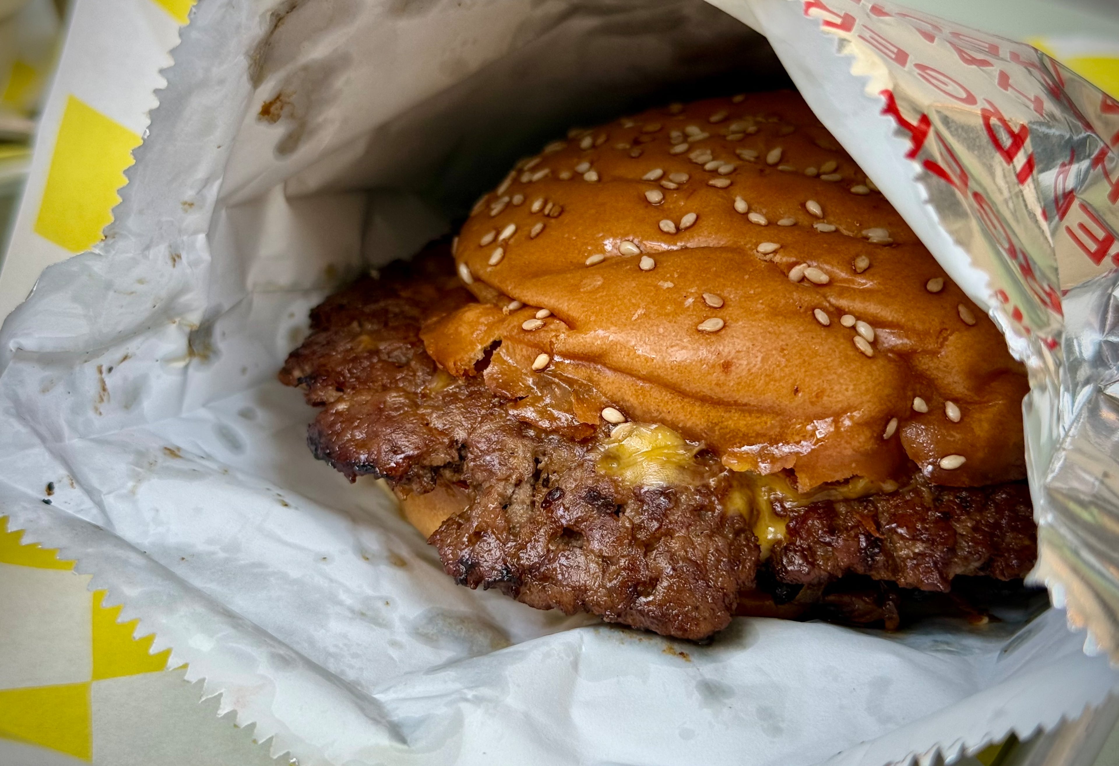 Sugar Loaf serves a deeply satisfying, messy smashburger in a retro foil bag. (Henri Hollis/AJC)