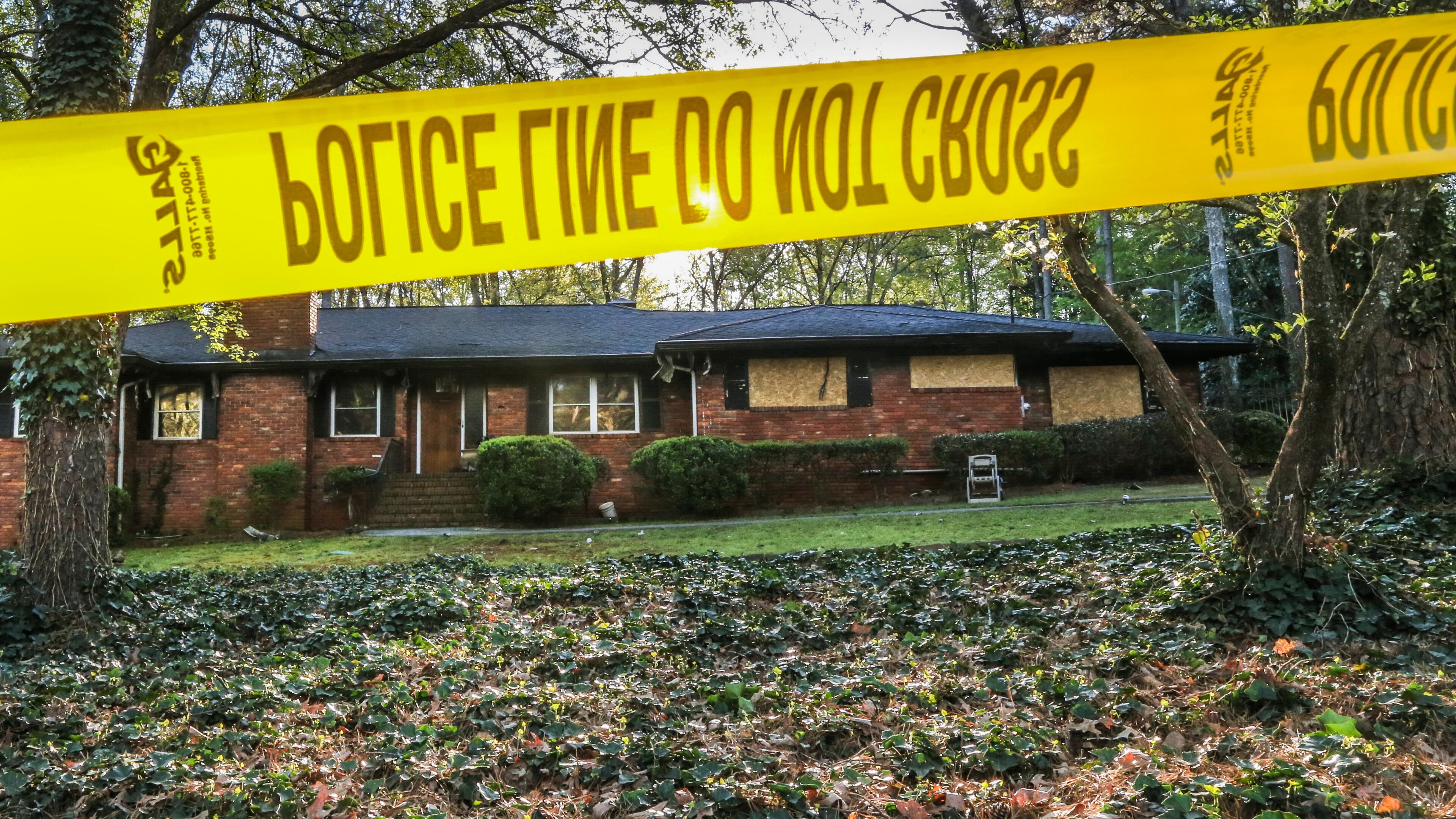 Crime tape surrounded an Oriole Drive home Mon., Apr. 4, 2016, two days after firefighters found a body severely burned in a pool Saturday. JOHN SPINK / JSPINK@AJC.COM