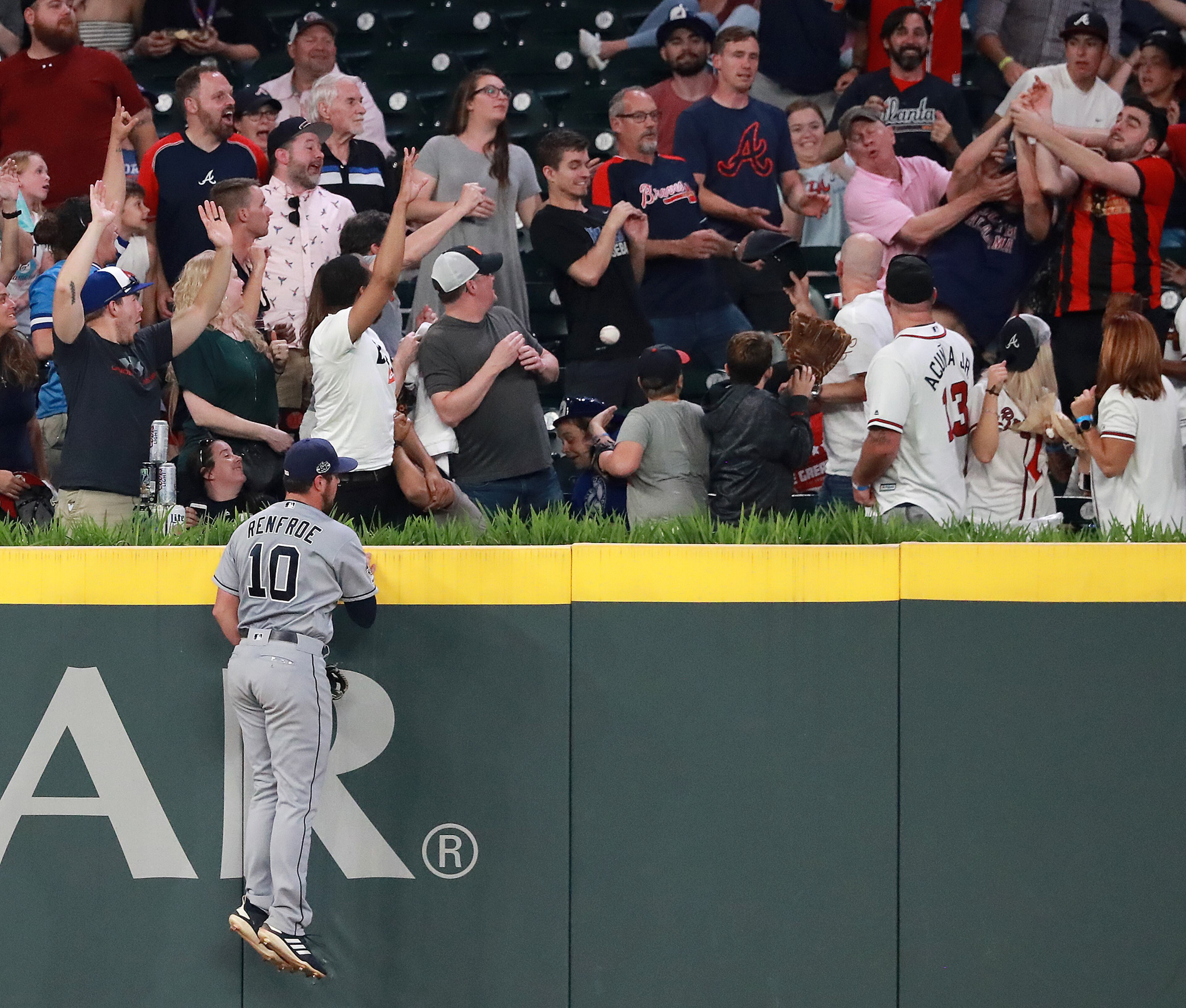 Padres outfielder Hunter Renfroe climbs the wall but can't reach Dansby Swanson's home run. Curtis Compton/ccompton@ajc.com
